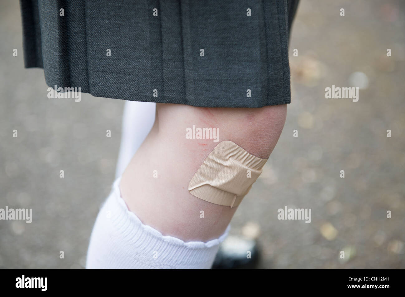 Schulmädchen Knie mit einem Heftpflaster über einen Schnitt. Stockfoto