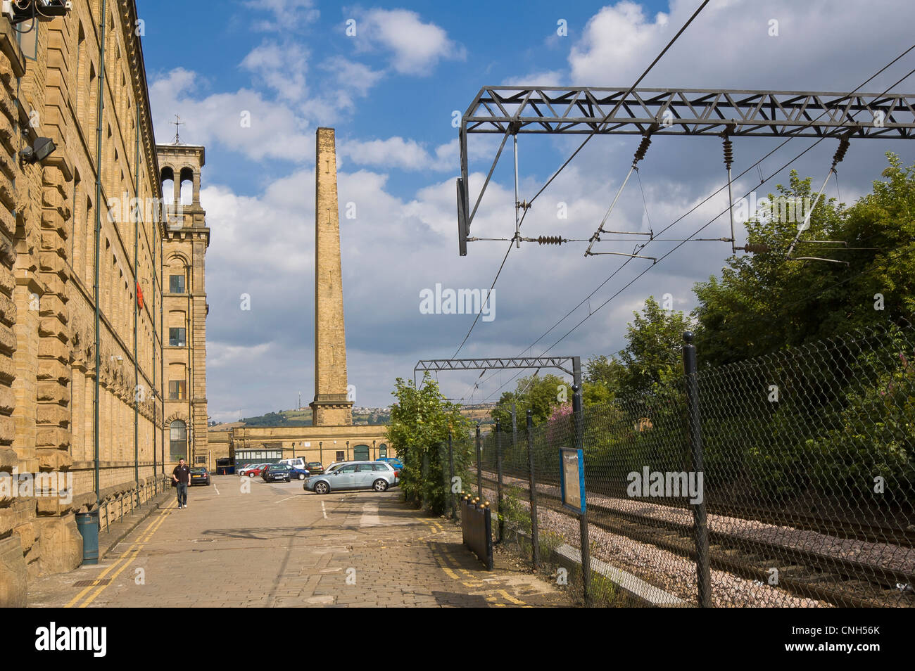 Saltaire in Leed Bradford, West Yorkshire mit den hohen Schornstein in den Hintergrund und die Bahnlinie nach rechts Stockfoto