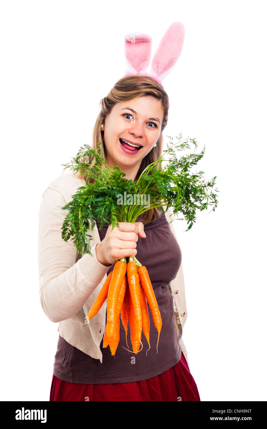 Lustige glücklich lachende Frau mit Hasenohren halten frische Karotten, isoliert auf weißem Hintergrund. Stockfoto