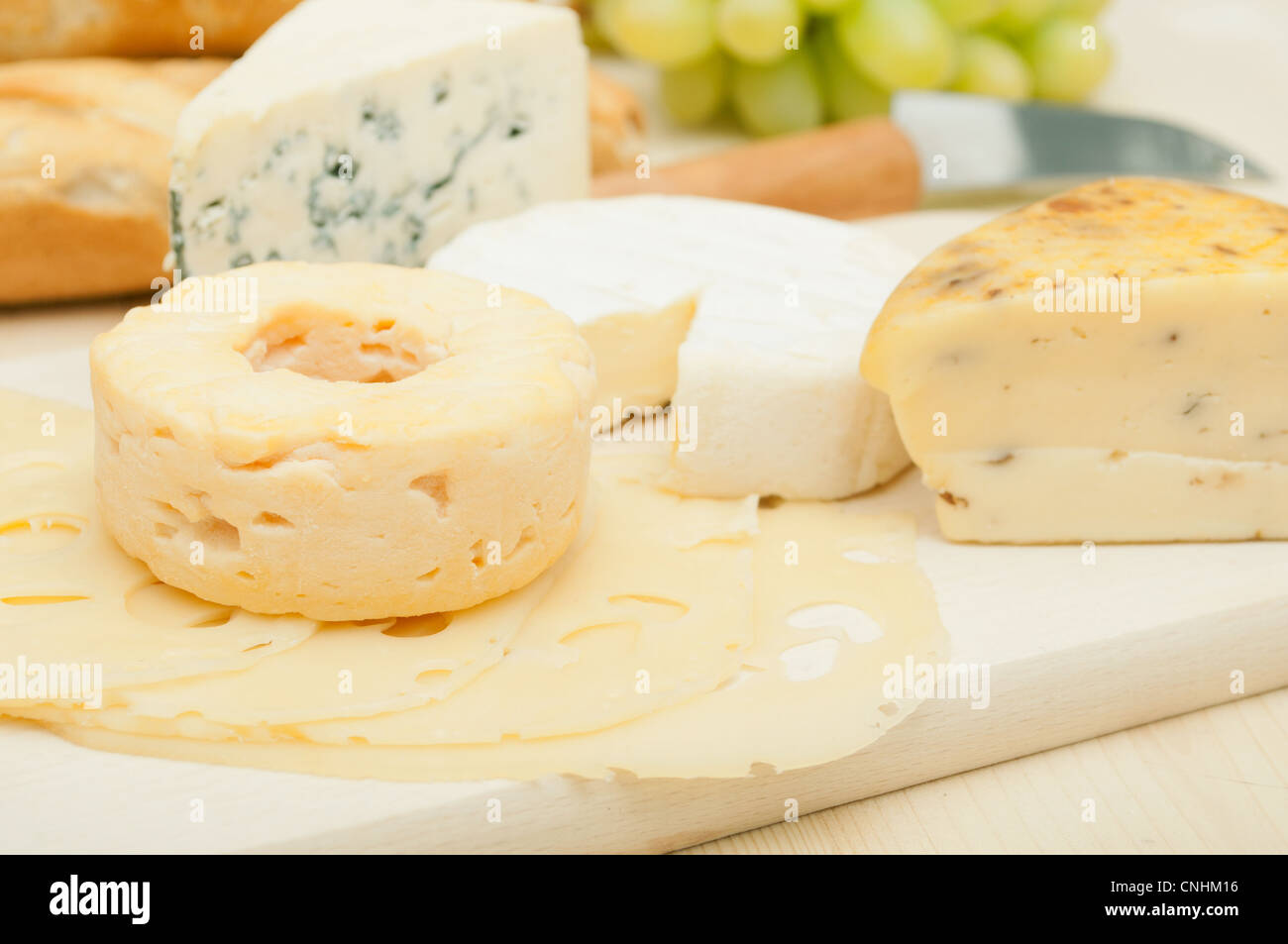 Verschiedene Arten von Käse und Trauben auf Schneidbrett aus Holz Stockfoto