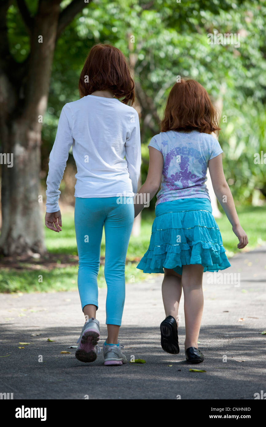 Mädchen hand in hand durch den Park gehen Stockfoto