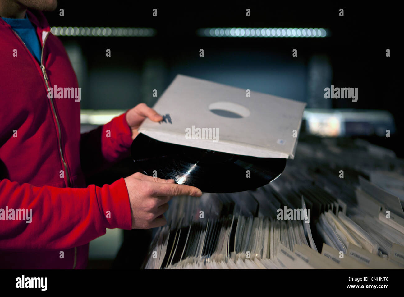 Ein Mann, der einen Datensatz aus dem Ärmel in einem Plattenladen Stockfoto