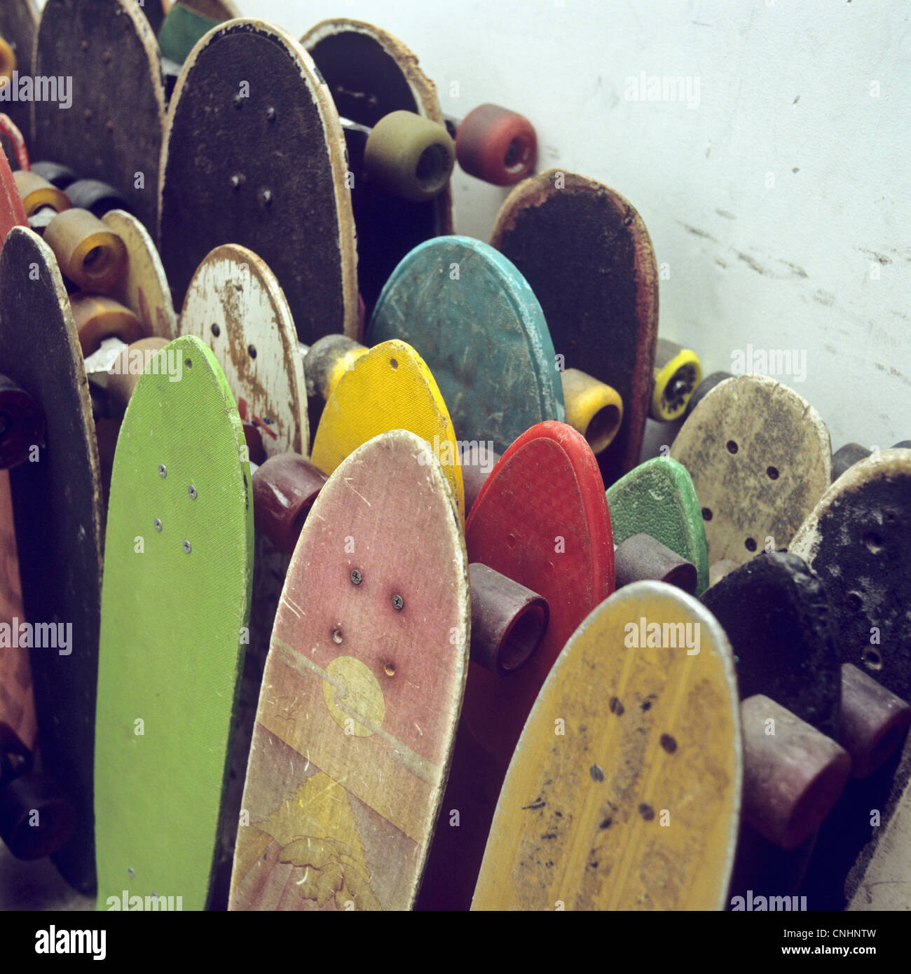 Reihen von gebrauchten Skateboards an eine Wand gelehnt Stockfoto