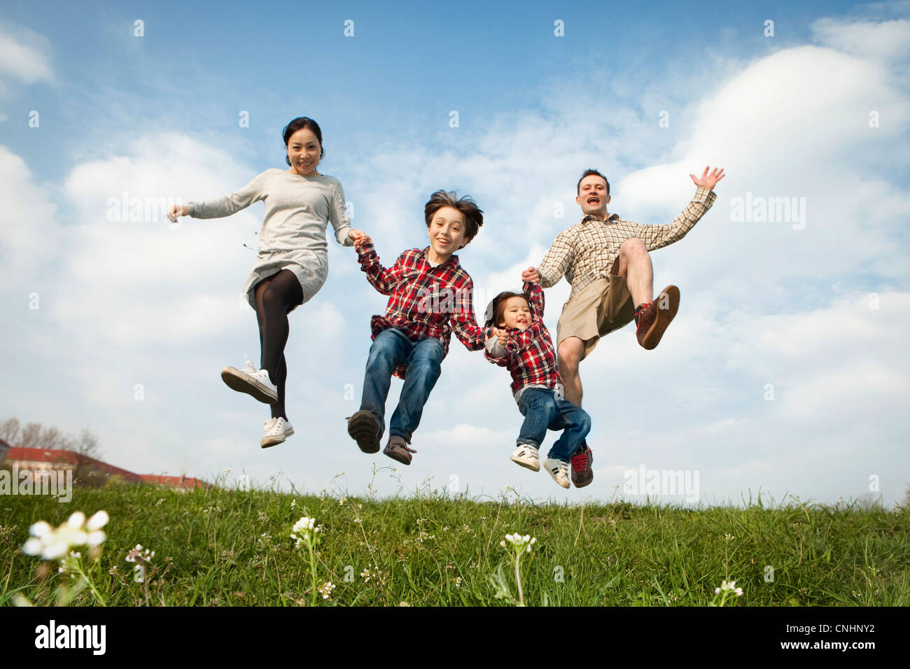 Eine Familie Hand in Hand und in die Luft springen Stockfoto