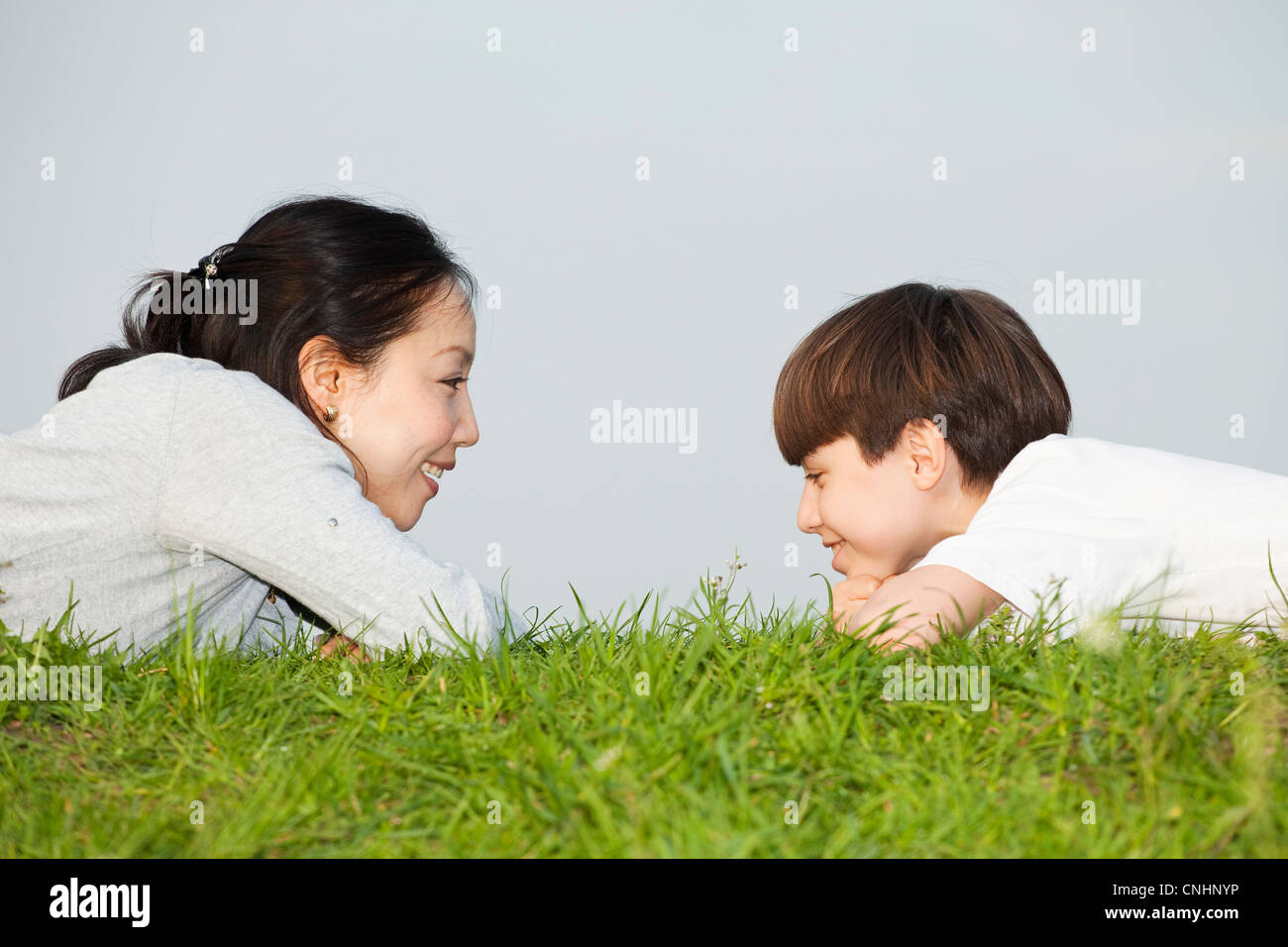 Mutter und Sohn liegend auf dem Bauch von Angesicht zu Angesicht Stockfoto