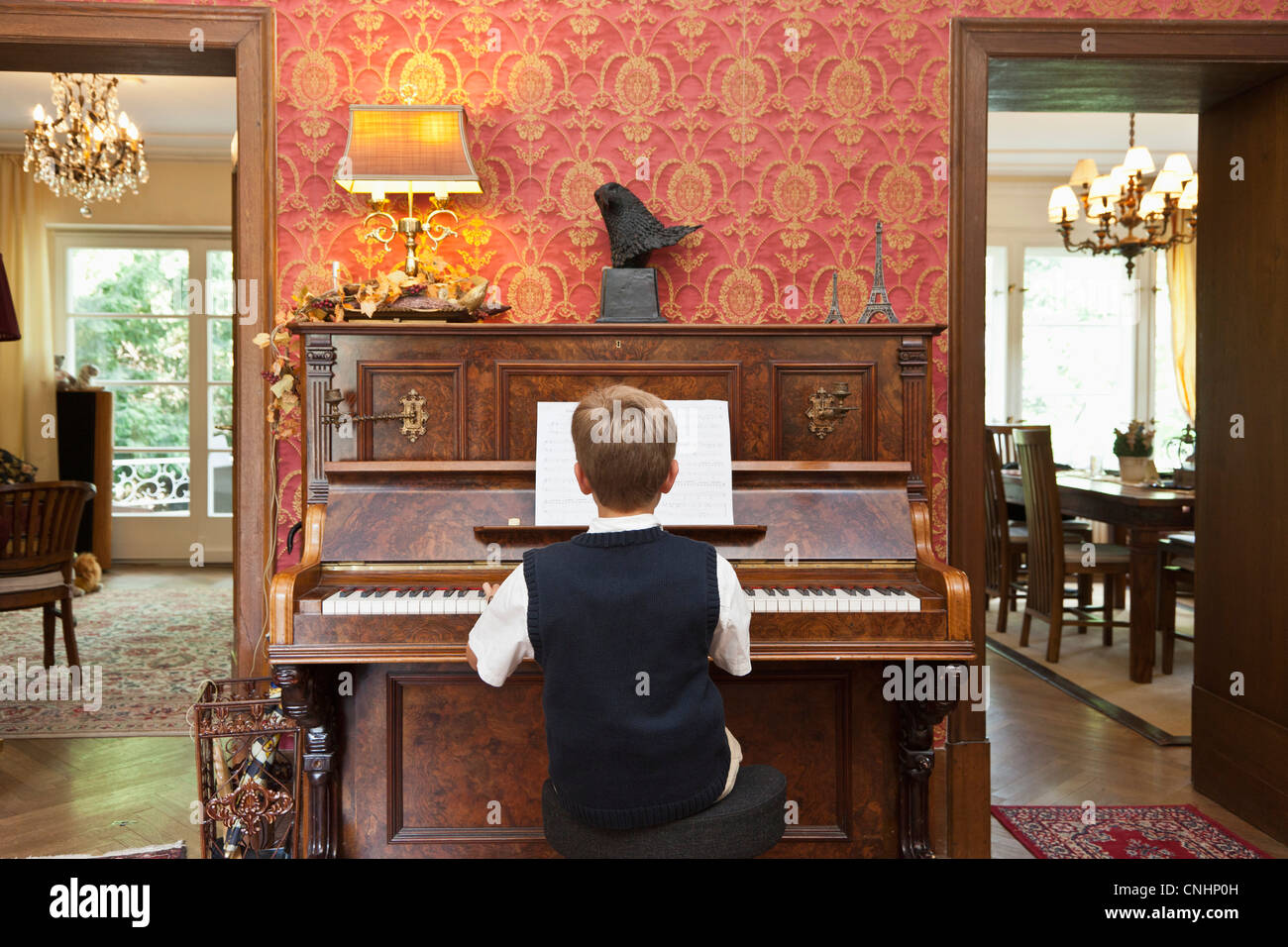 Ein Junge auf einem altmodischen Klavier üben Stockfoto