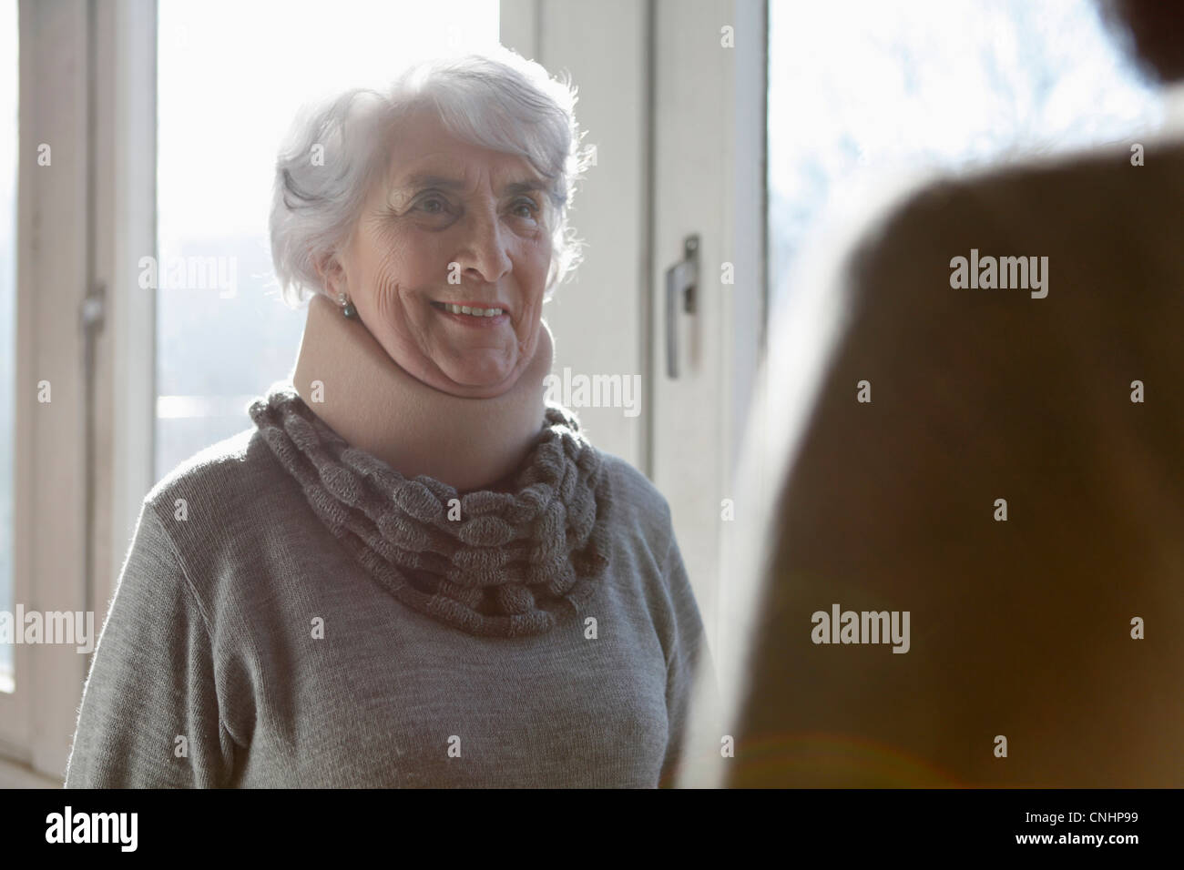 Eine lächelnde senior Frau tragen einer Halskrause Stockfoto