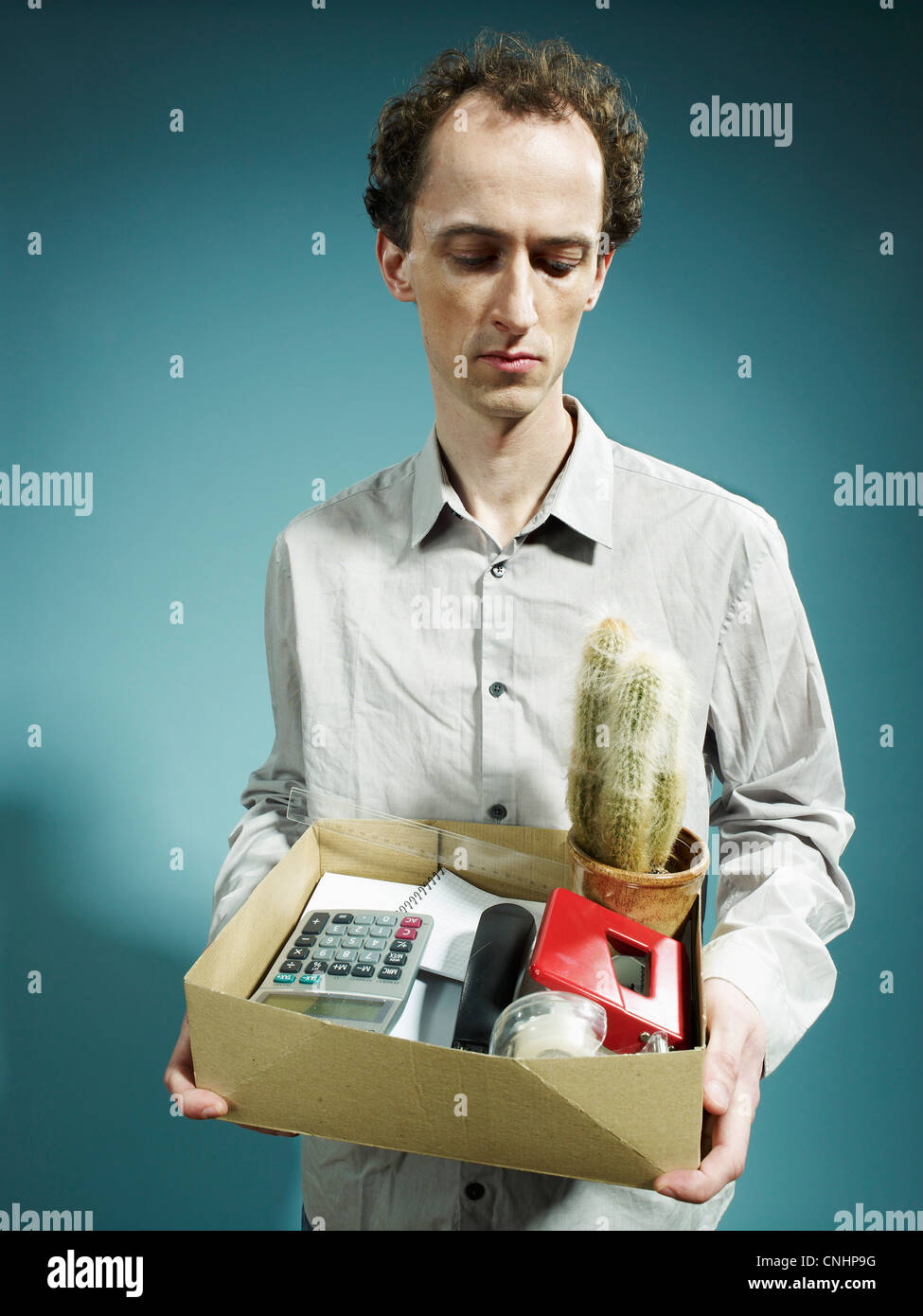 Ein Mann trägt eine Schachtel mit Besitzungen nach gefeuert Stockfoto