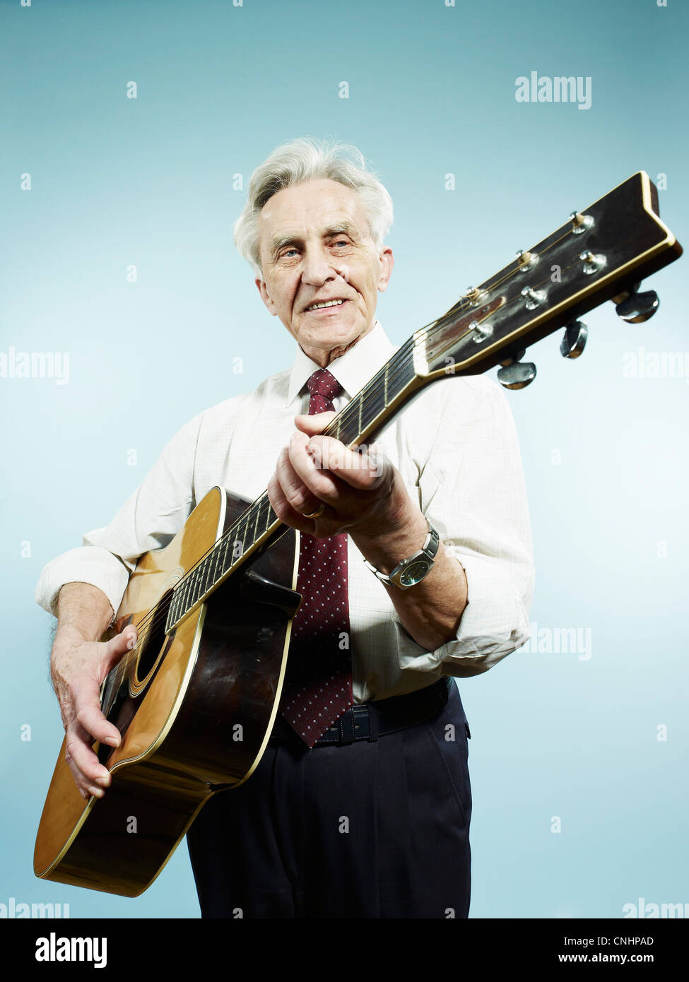 Ein senior Mann spielt eine akustische Gitarre Stockfoto