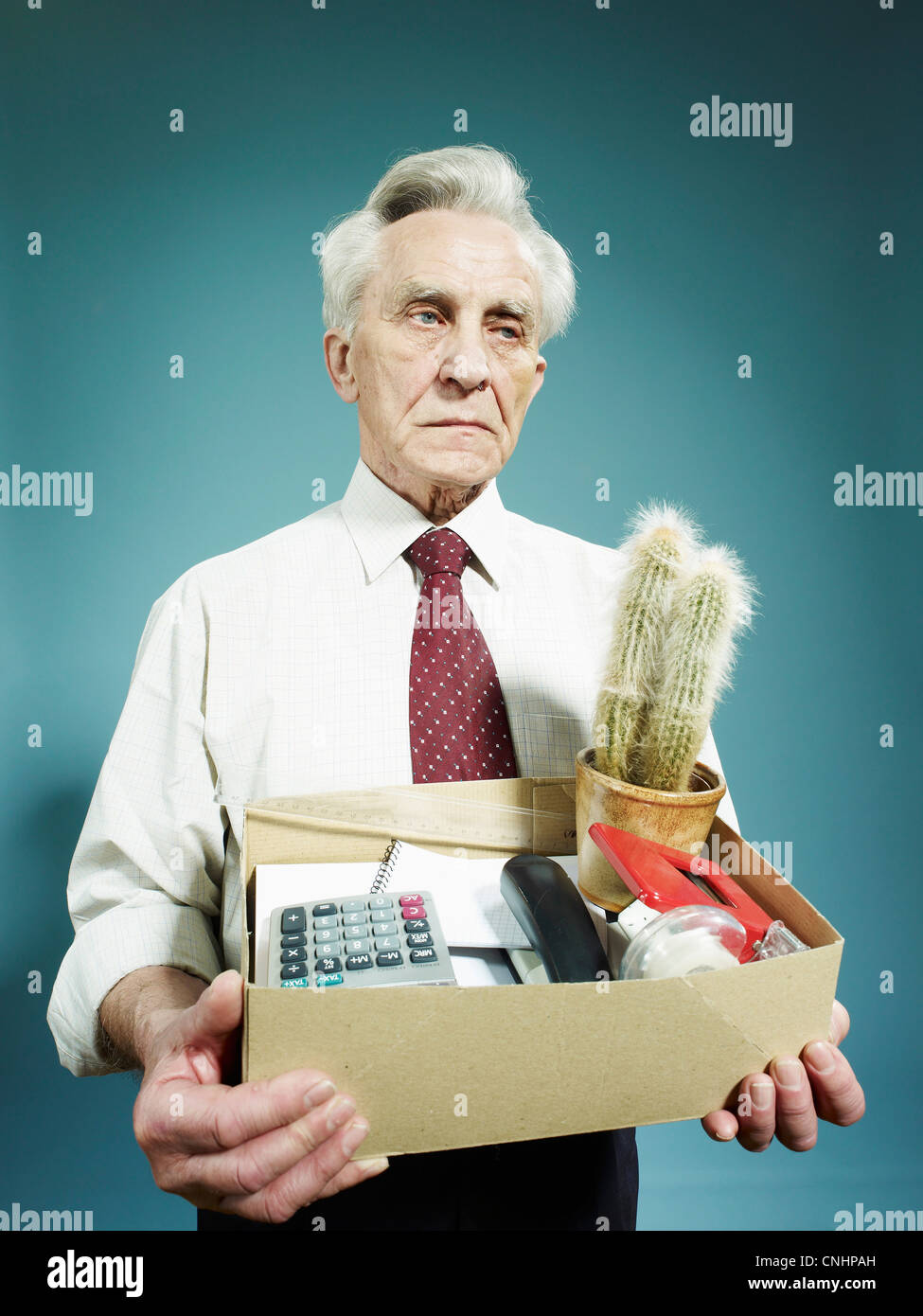 Ein senior Mann trägt eine Schachtel mit Besitzungen nach gefeuert Stockfoto