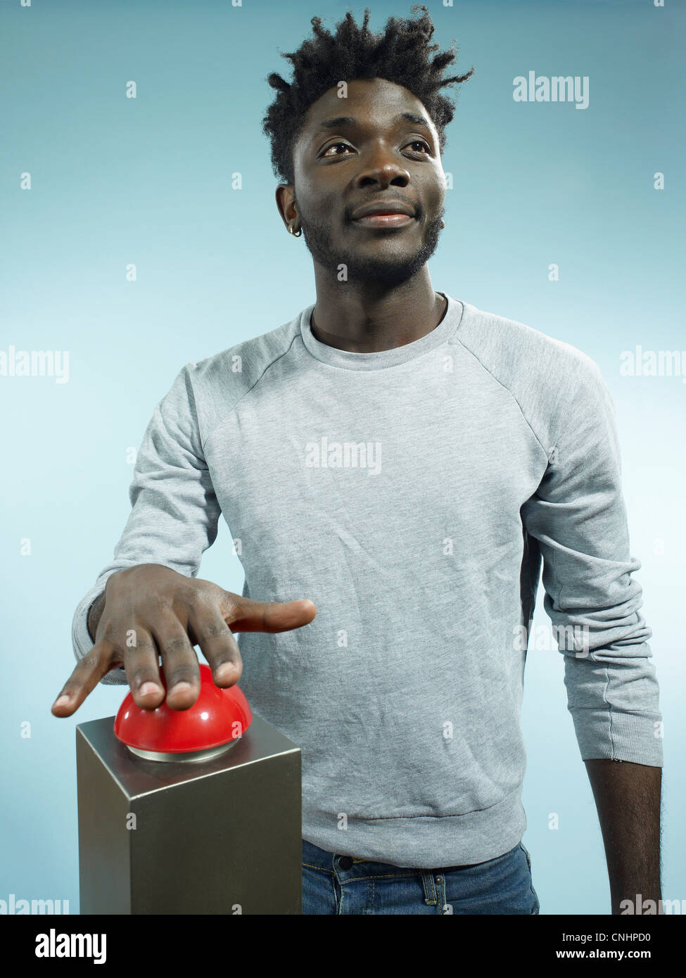 Ein hip junger Mann mit seiner Hand balanciert über einen roten Gameshow-Summer Stockfoto