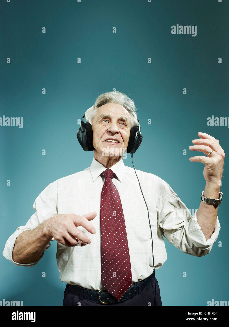 Ein senior Mann tragen von Kopfhörern und Luftgitarre zu spielen Stockfoto