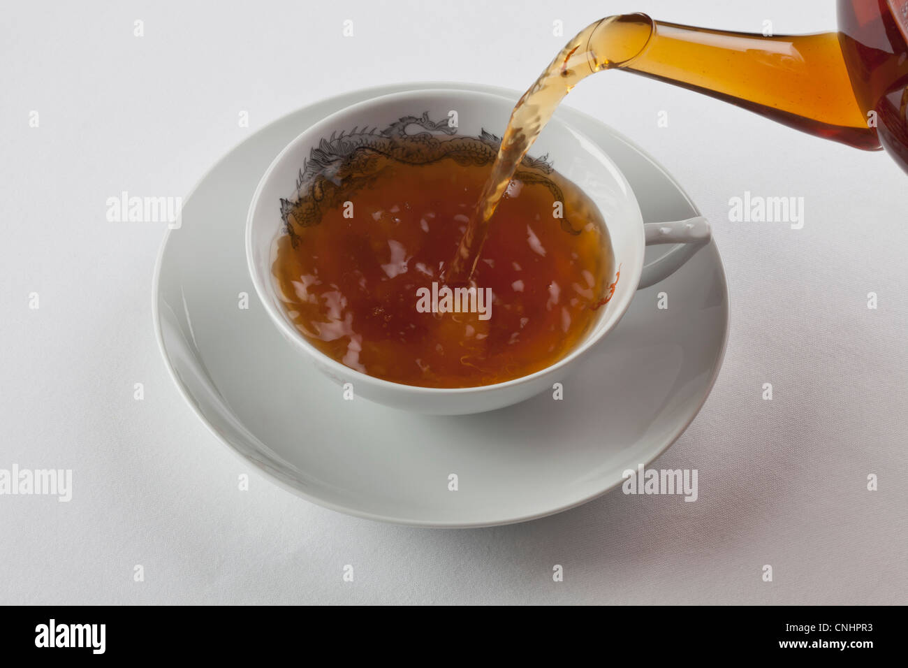 Detail einer Tasse schwarzen Tee gegossen wird Stockfoto