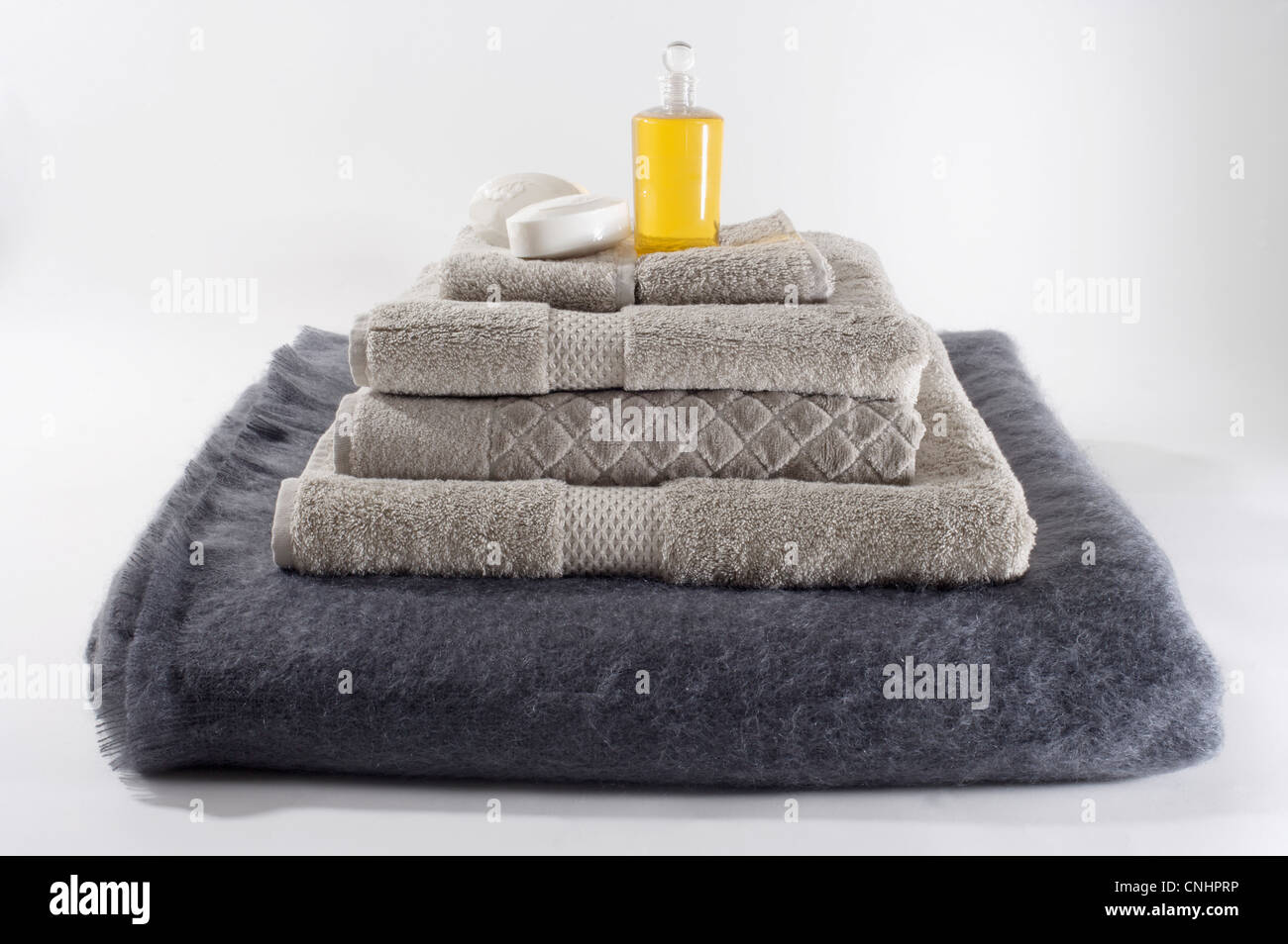 Stapel von gefaltete Handtücher mit ein Stück Seife und Massage Öl an der Spitze Stockfoto
