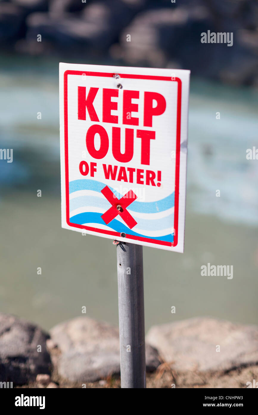 Ein Keep Out of Water-Schild an einem steinigen Strand Stockfoto