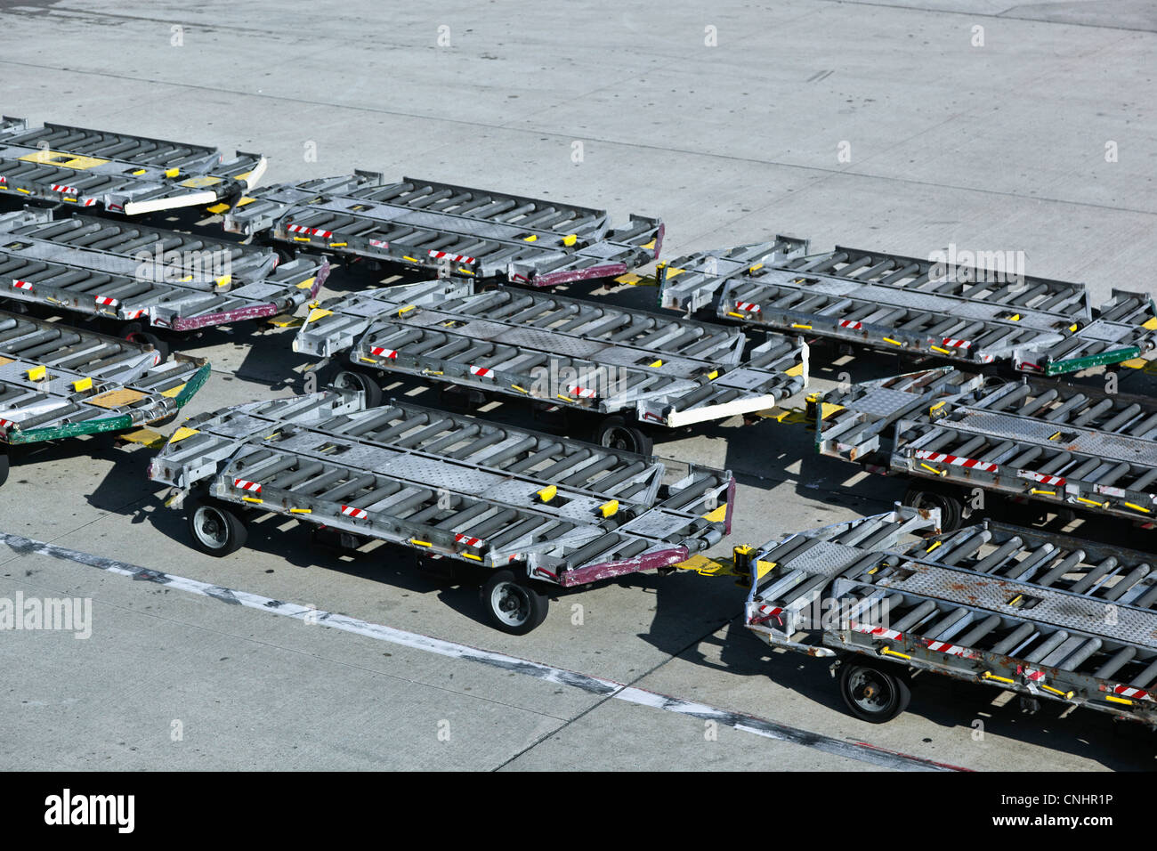 Leere Gepäck Anhänger auf einem Flughafen-Asphalt Stockfoto