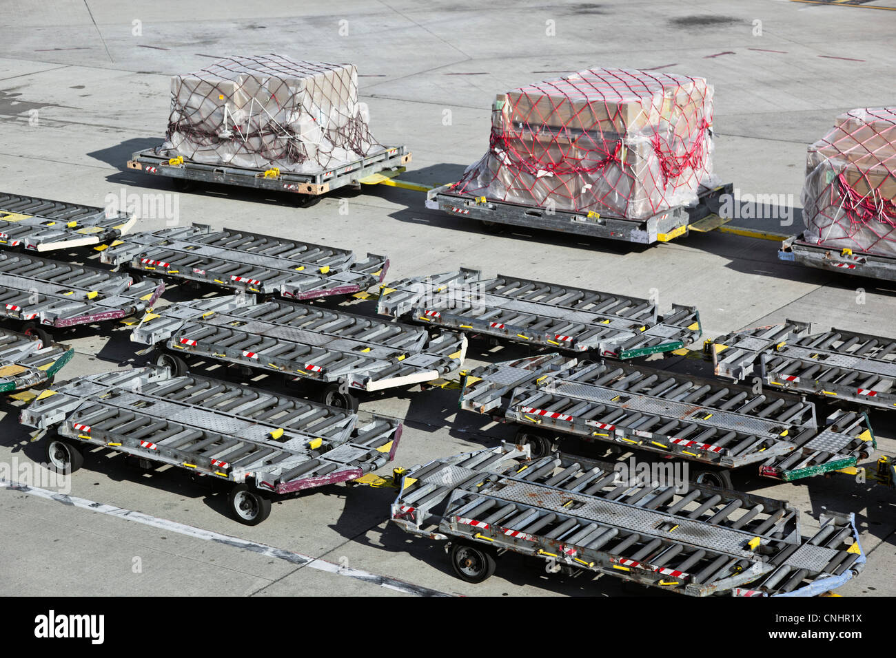 Leere Gepäck Anhänger und Fracht auf einem Flughafen-Asphalt Stockfoto