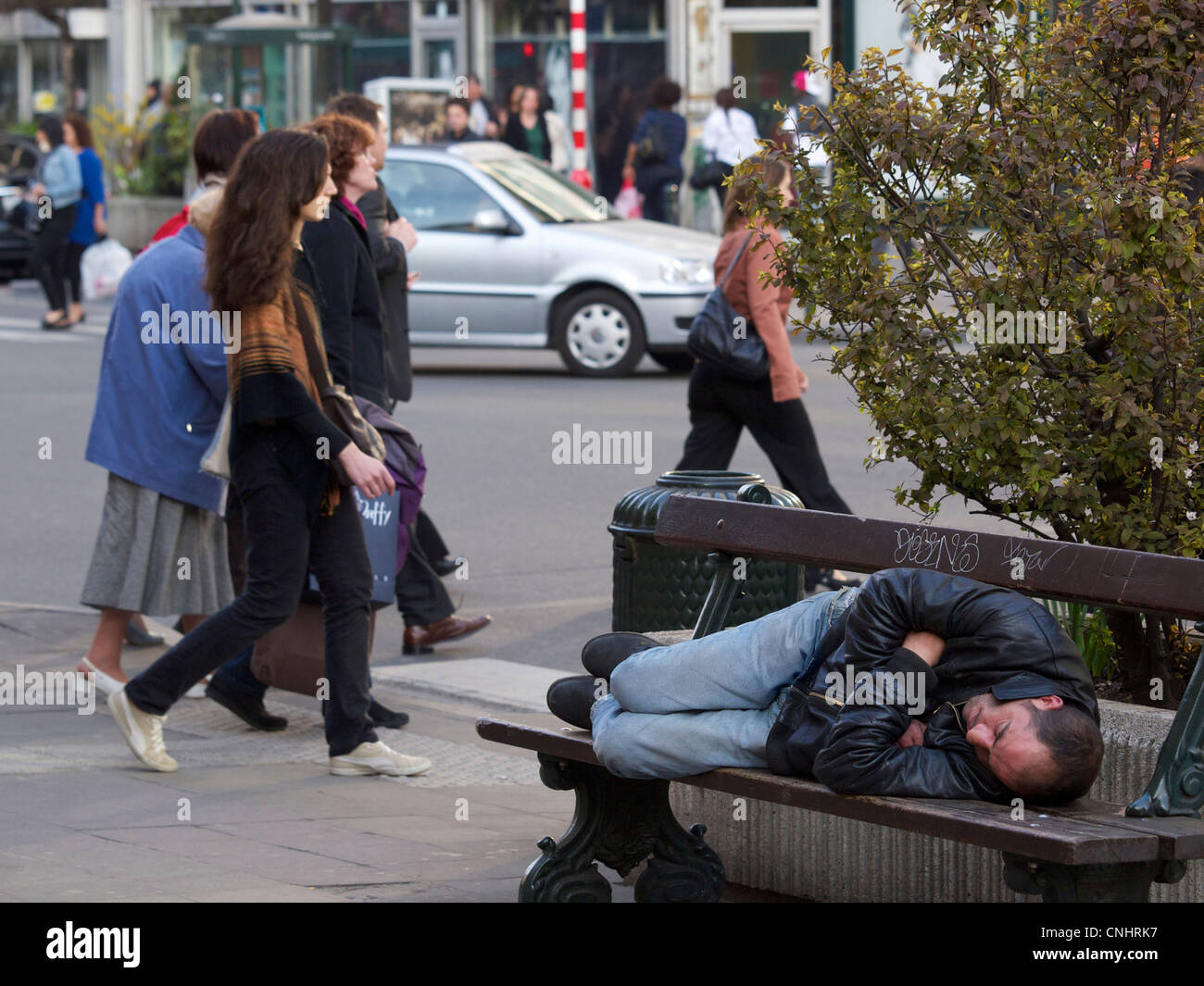 Obdachloser schlafen auf einer Bank in den belebten Straßen von Brüssel, Belgien Stockfoto