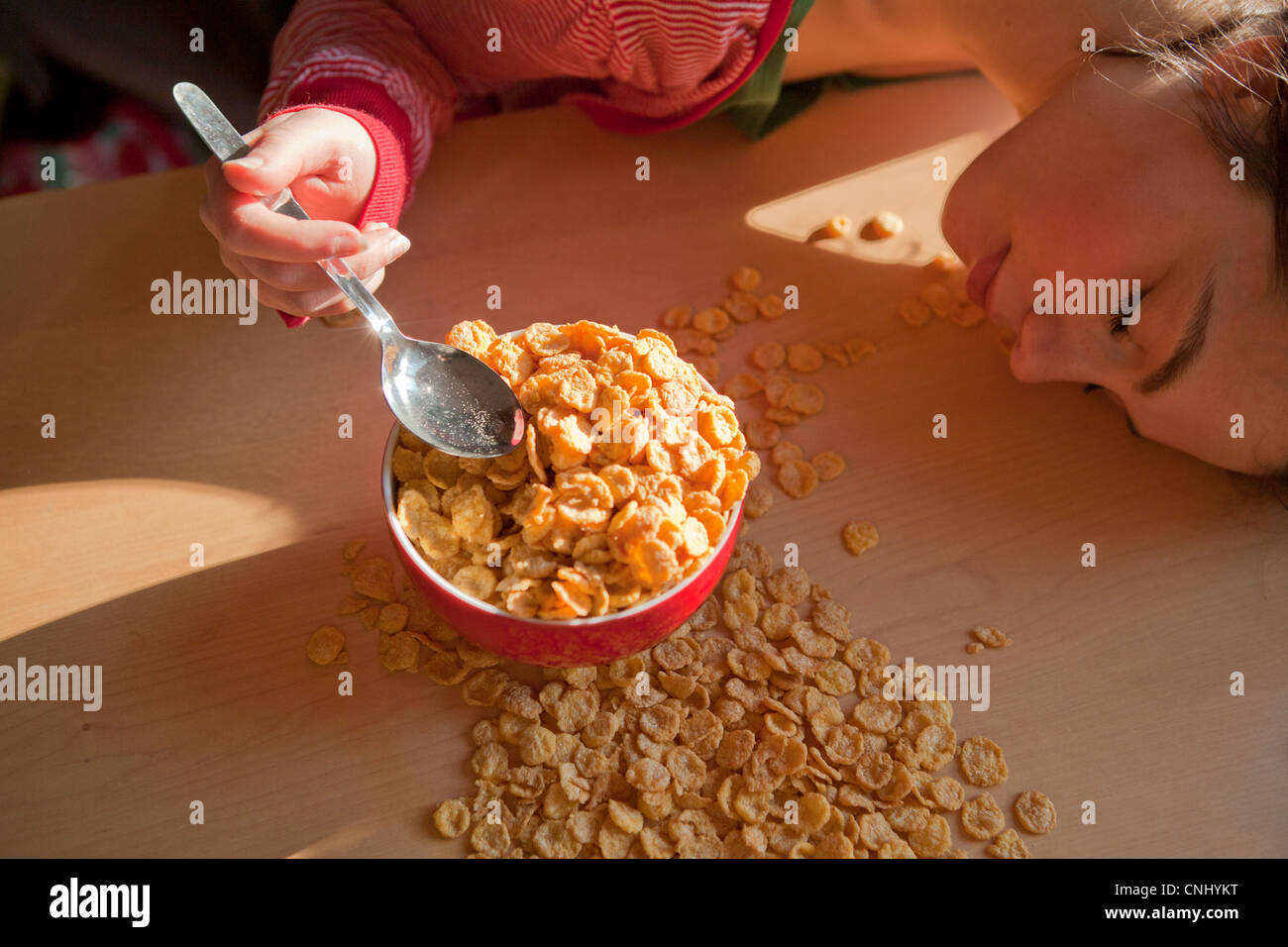 Junge Frau mit verschüttete Frühstücks-Cerealien Stockfoto