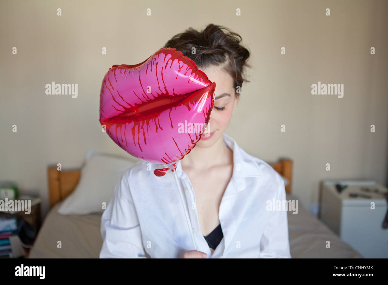 Junge Frau mit Lippen-förmigen Ballon Stockfoto