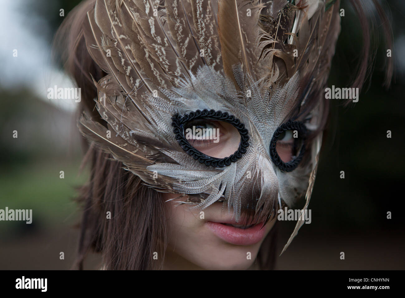 Junge Frau trägt eine Maske von Federn Stockfoto