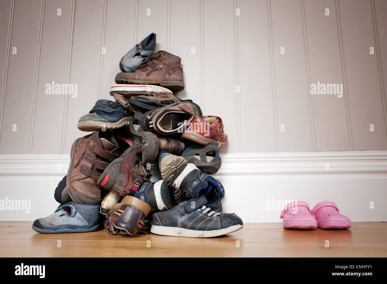 Große Haufen von jungen Schuhe neben ein paar Mädchen Schuhe Stockfoto