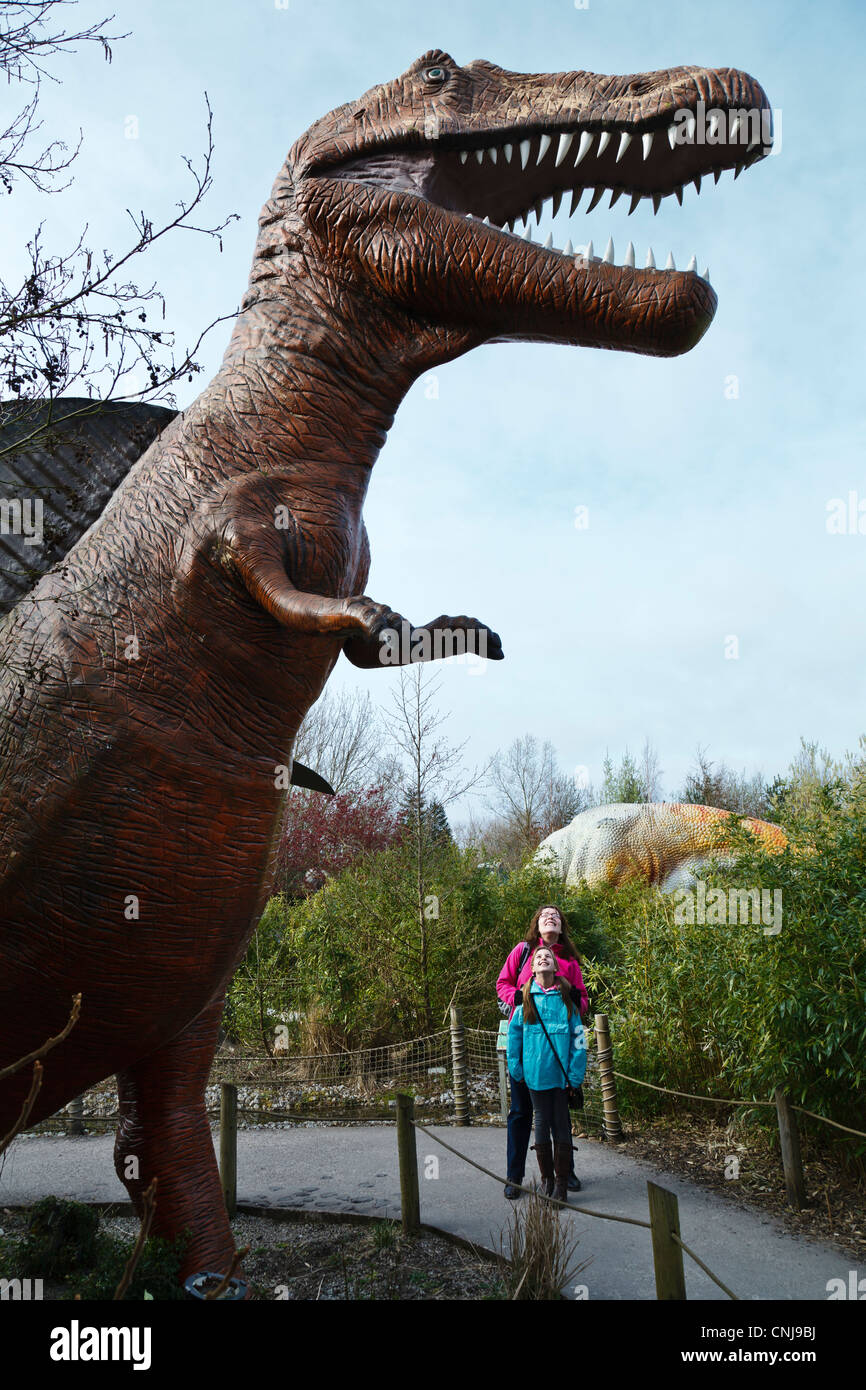 Besucher in den Schatten gestellt durch ein Modell Spinosaurus in Dinosaur Safari im Zoo von Blackpool. Stockfoto