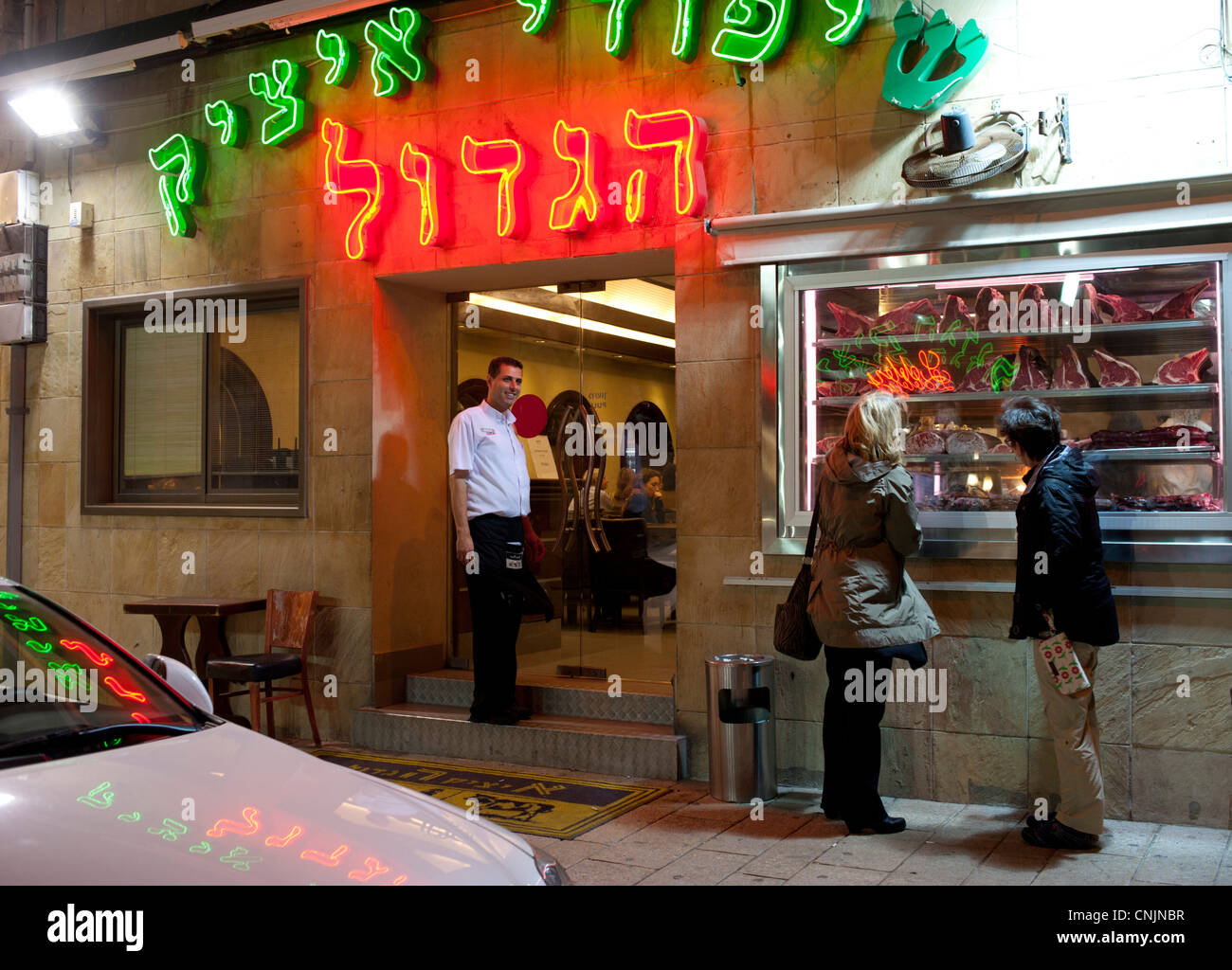 Nahost Israel Old Jaffa (Baeume) Itzik Hagadol Restaurant außen bei Nacht Neon, Menschen auf der Suche am Fenster Stockfoto