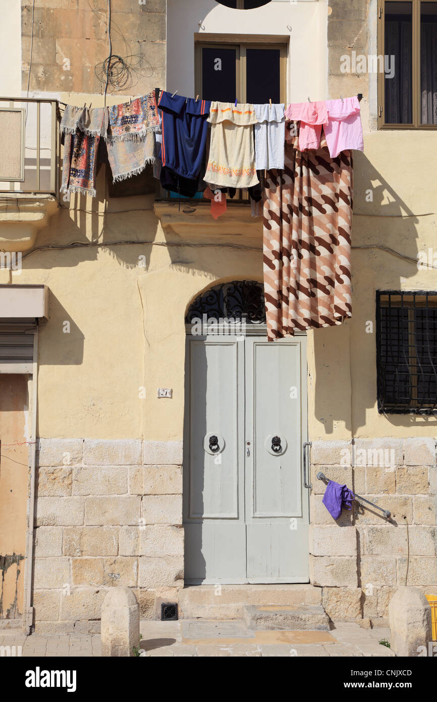 Wäsche trocknen auf Linie über der Tür von einem traditionellen Fischerhaus in Marsaxlokk, Malta, Europa Stockfoto