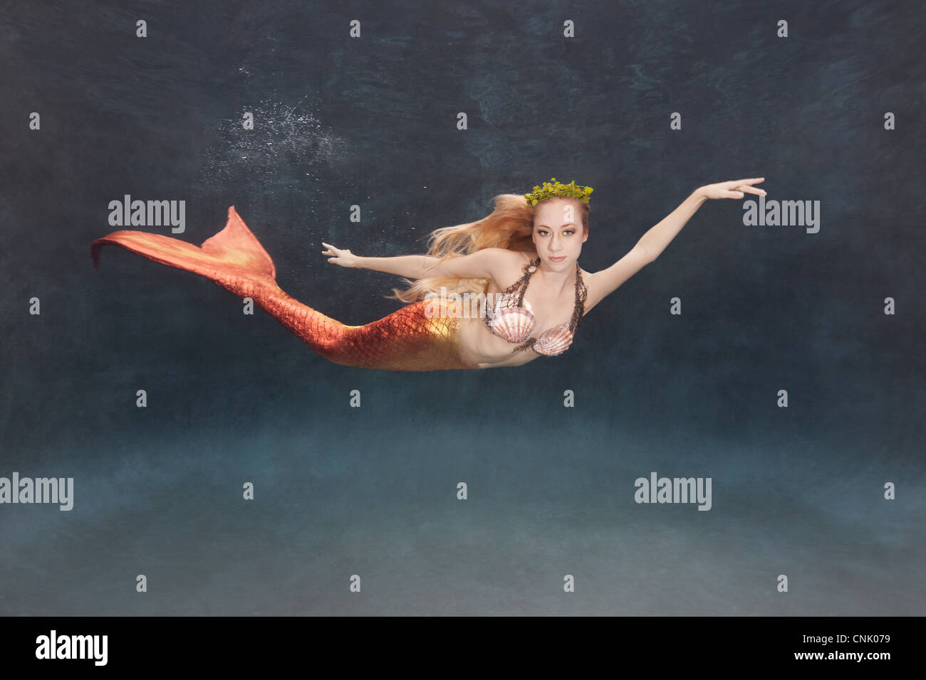 Meerjungfrau Schwimmen unter Wasser mit einer Seetang-Krone Stockfoto