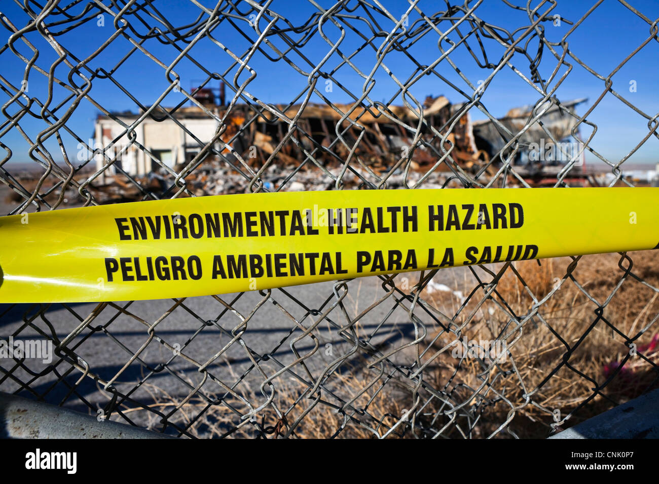 Ökologische Gefahr für die Gesundheit Warnung Klebeband auf ein Maschendrahtzaun. Stockfoto