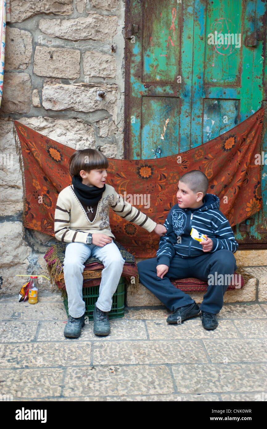 Nahost Israel Altstadt Jerusalem zwei Jungs in der Christian Quarter sitzen und den Austausch mit etwas zu essen. Stockfoto