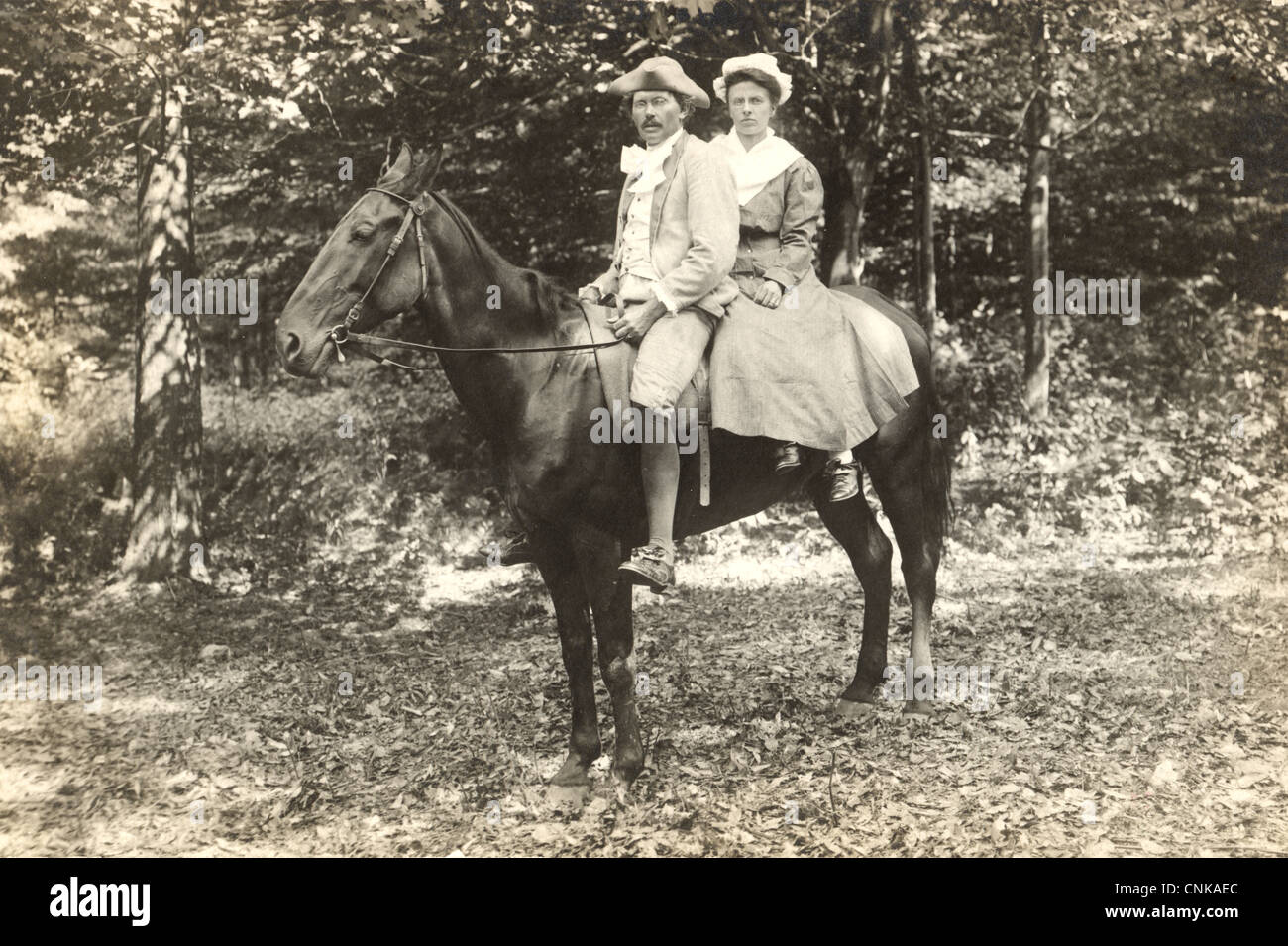 Paar in kolonialen Kostüme auf einem einzigen Pferd Stockfoto