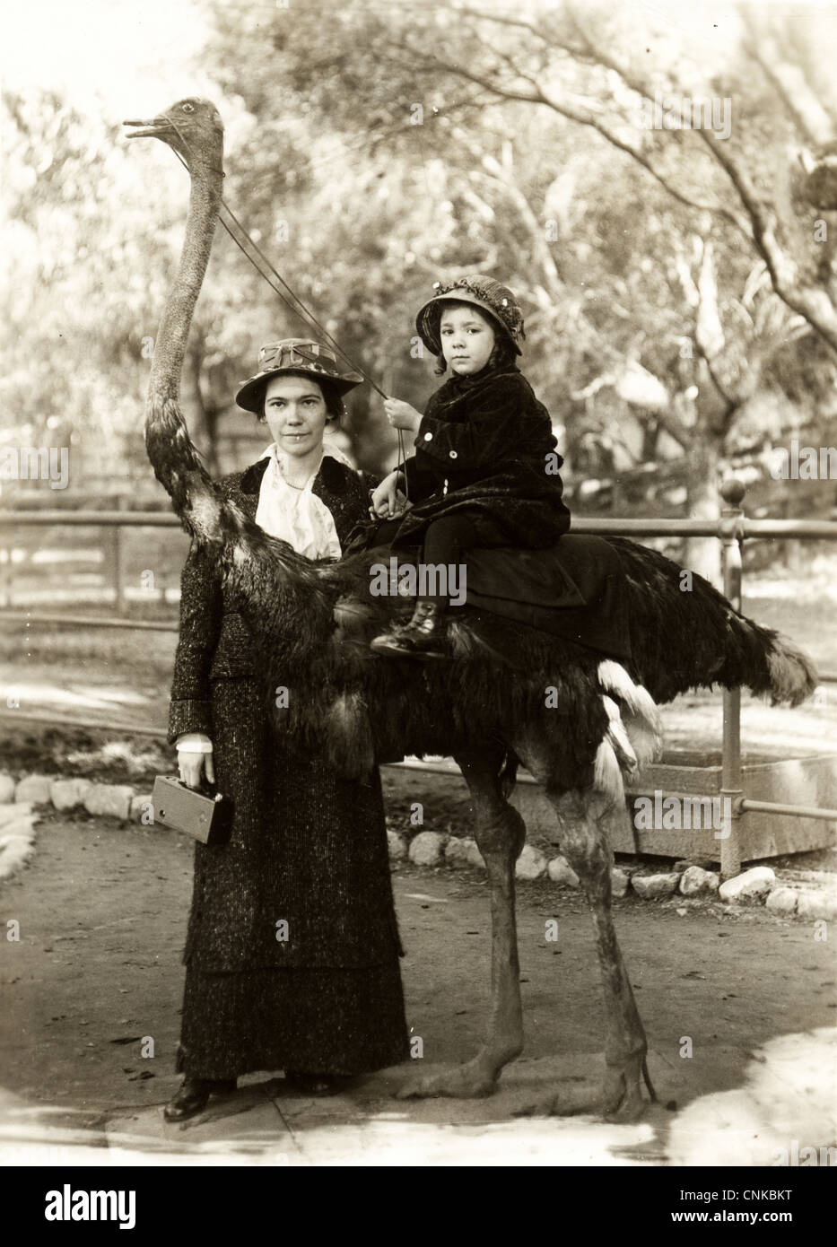 Junge Mutter mit Tochter Reiten ein Strauß Stockfoto