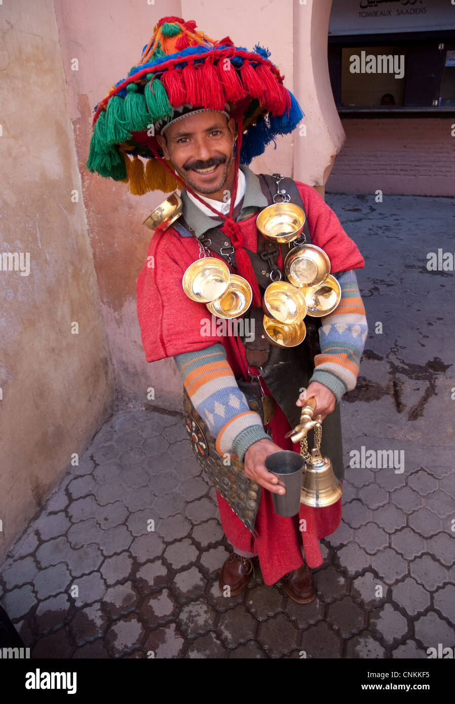 Die traditionelle Uniform und den spektakulären bunten Hut eines marokkanischen Wasser-Verkäufer in den Straßen von Marrakesch in Marokko Stockfoto