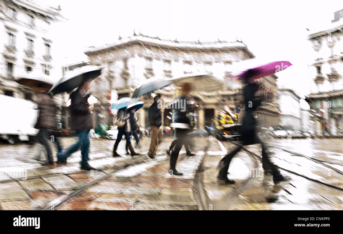 Absichtlich unscharf Bewegung abstraktes Bild von Pendlern in einer europäischen Stadt an einem regnerischen Tag. Gedreht in Mailand, Italien Stockfoto