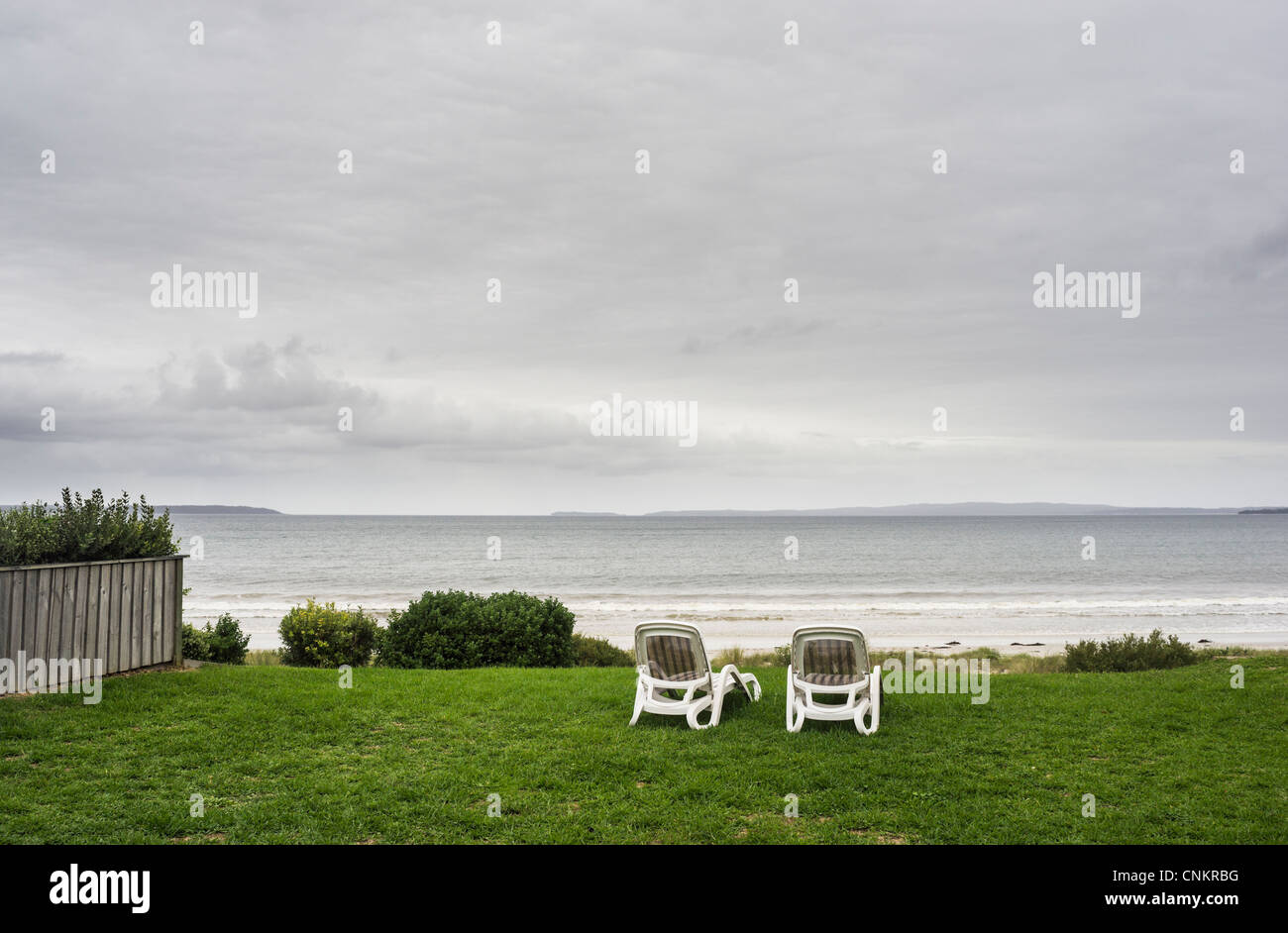 Liegestühle auf dem Rasen bei bewölktem Himmel Stockfoto