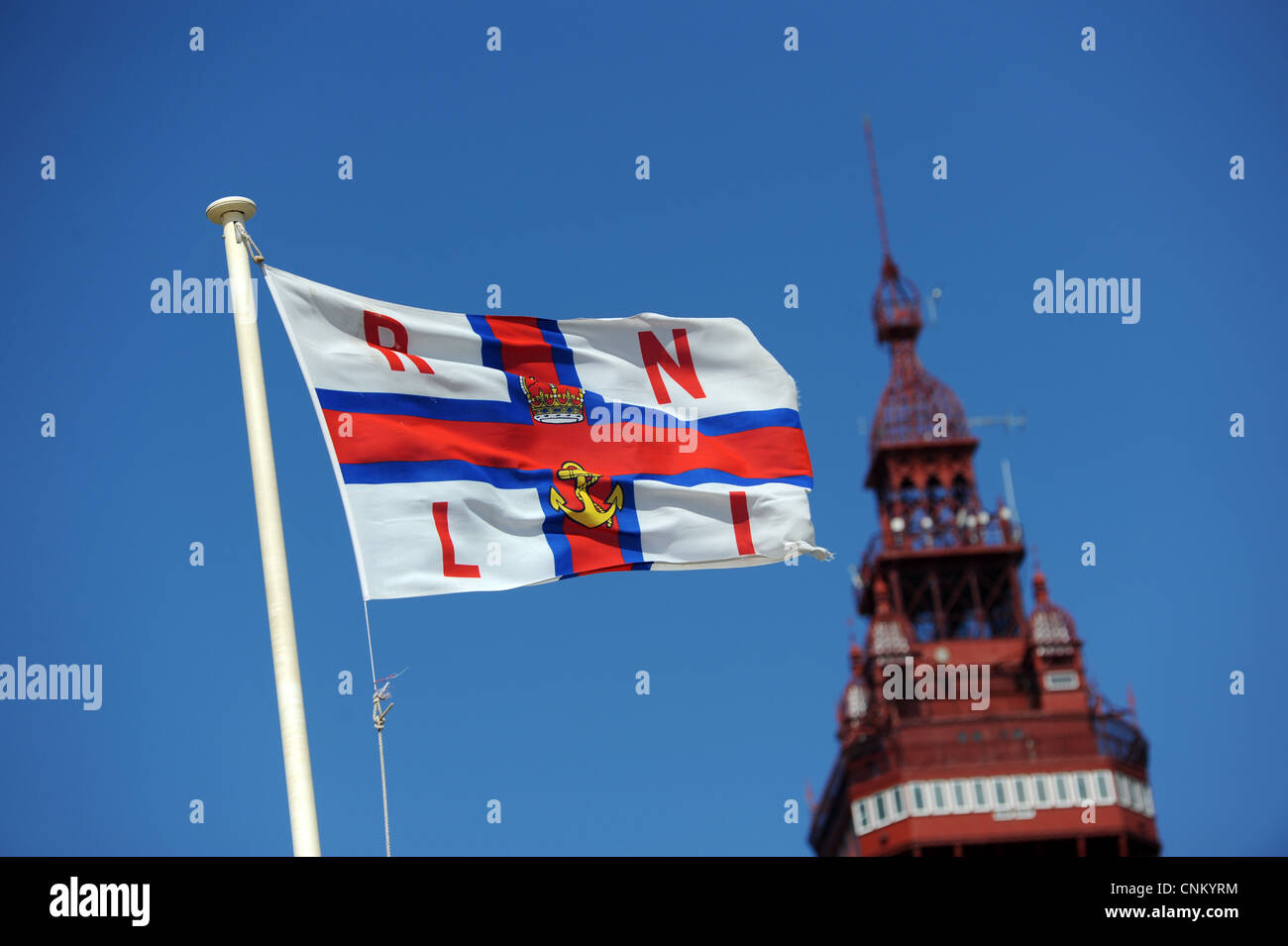 RNLI Flagge in Blackpool mit Turm im Hintergrund Stockfoto