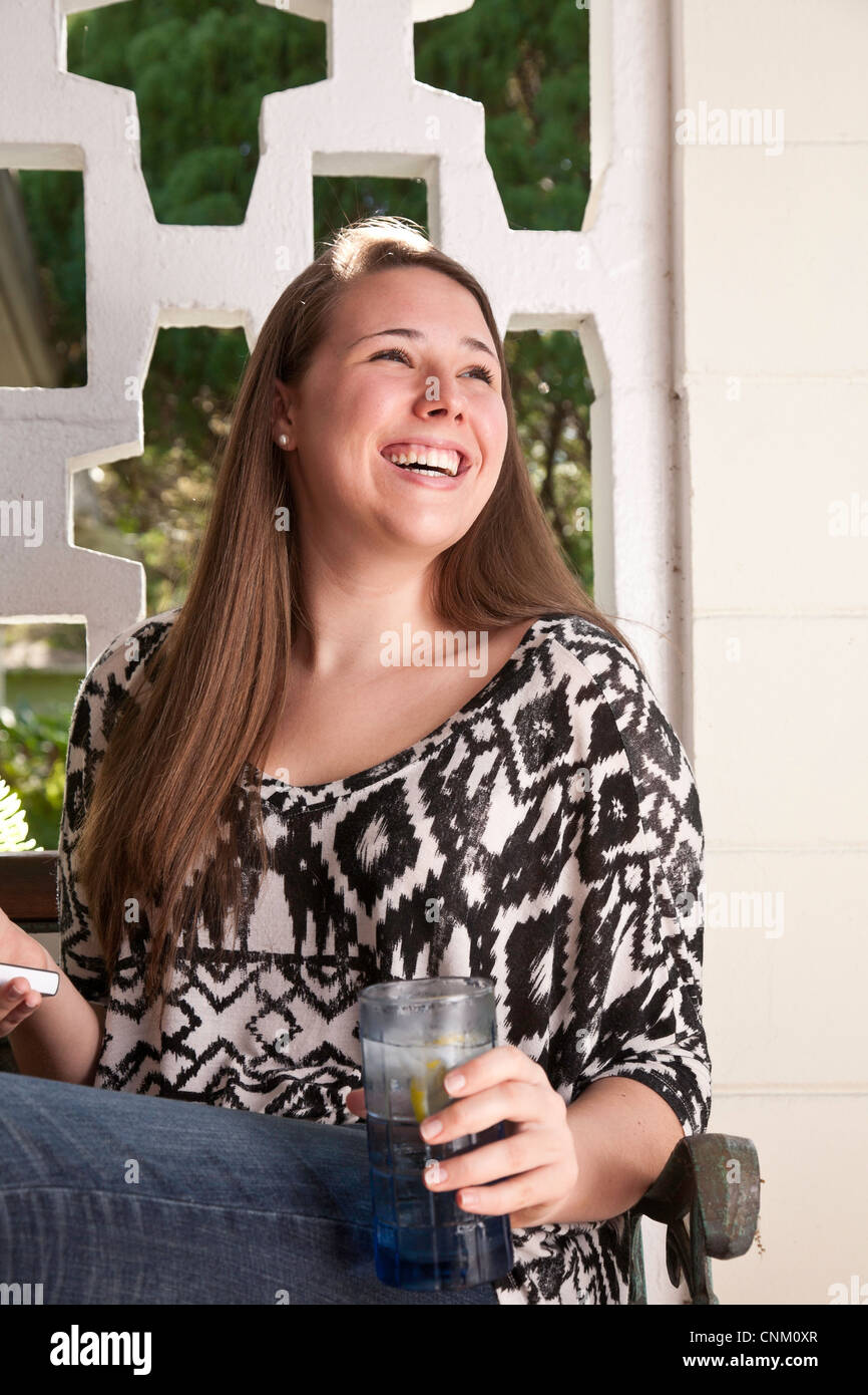 Lässige junge Frau genießt einen kühlen drink Stockfoto