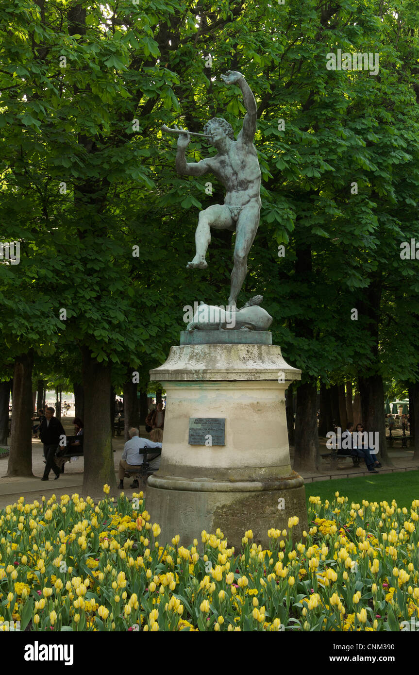 Die Bronze-Statue eines tanzenden Fauns von Eugène-Louis Lequesneist, umgeben von einem Bett von gelben Tulpen im Jardin du Luxembourg. Paris, Frankreich. Stockfoto