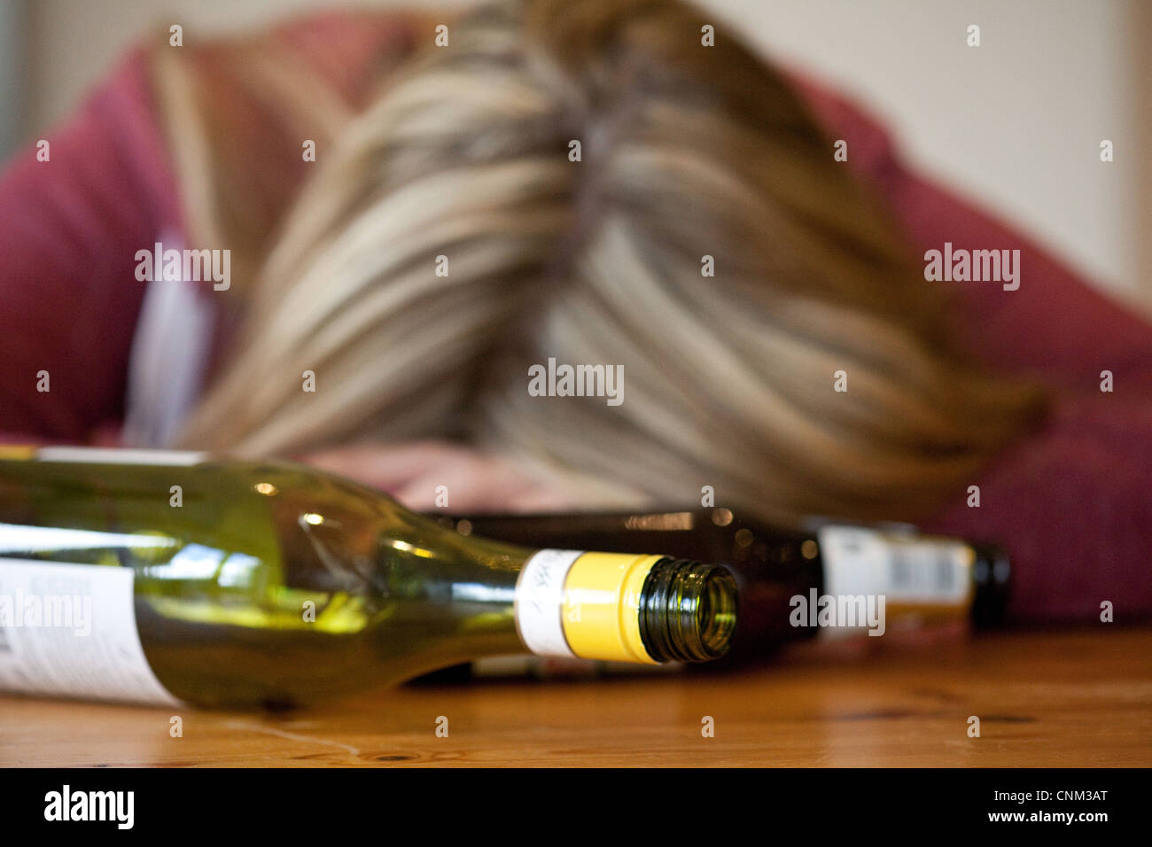 Junge blonde Frau betrunken, mit leeren Flaschen Alkohol, UK - gestellt durch ein Modell Stockfoto