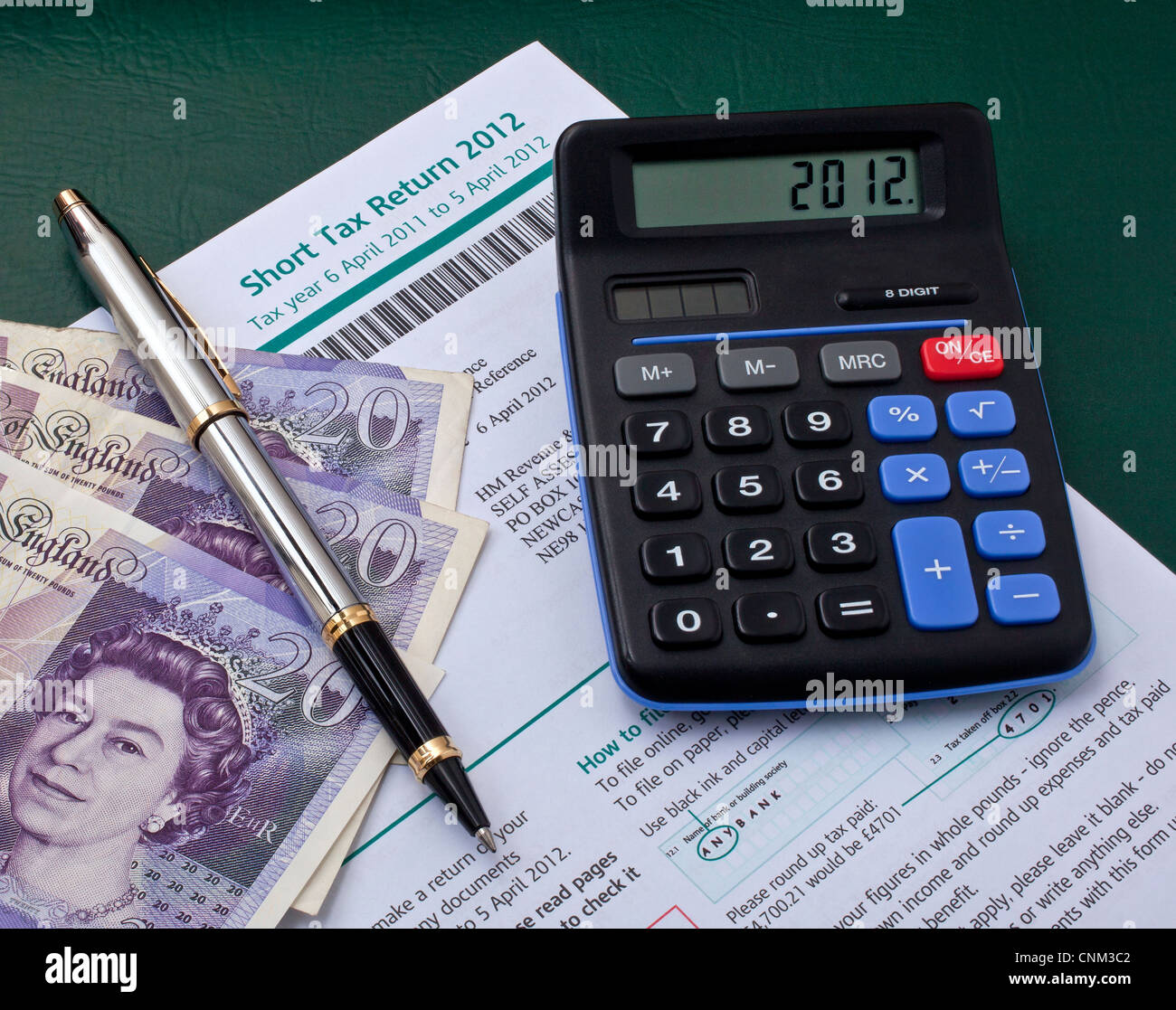 Britische Steuererklärung mit Taschenrechner, Kugelschreiber und Banknoten Stockfoto