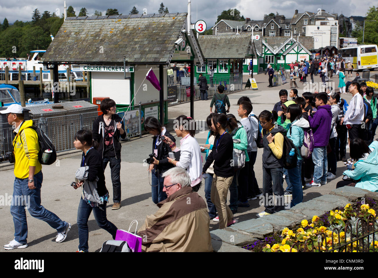 China tour Gruppe von jungen Teenagern die digitalen Fotos von Schwänen und füttern in Bowness Bay am Lake Windermere Stockfoto