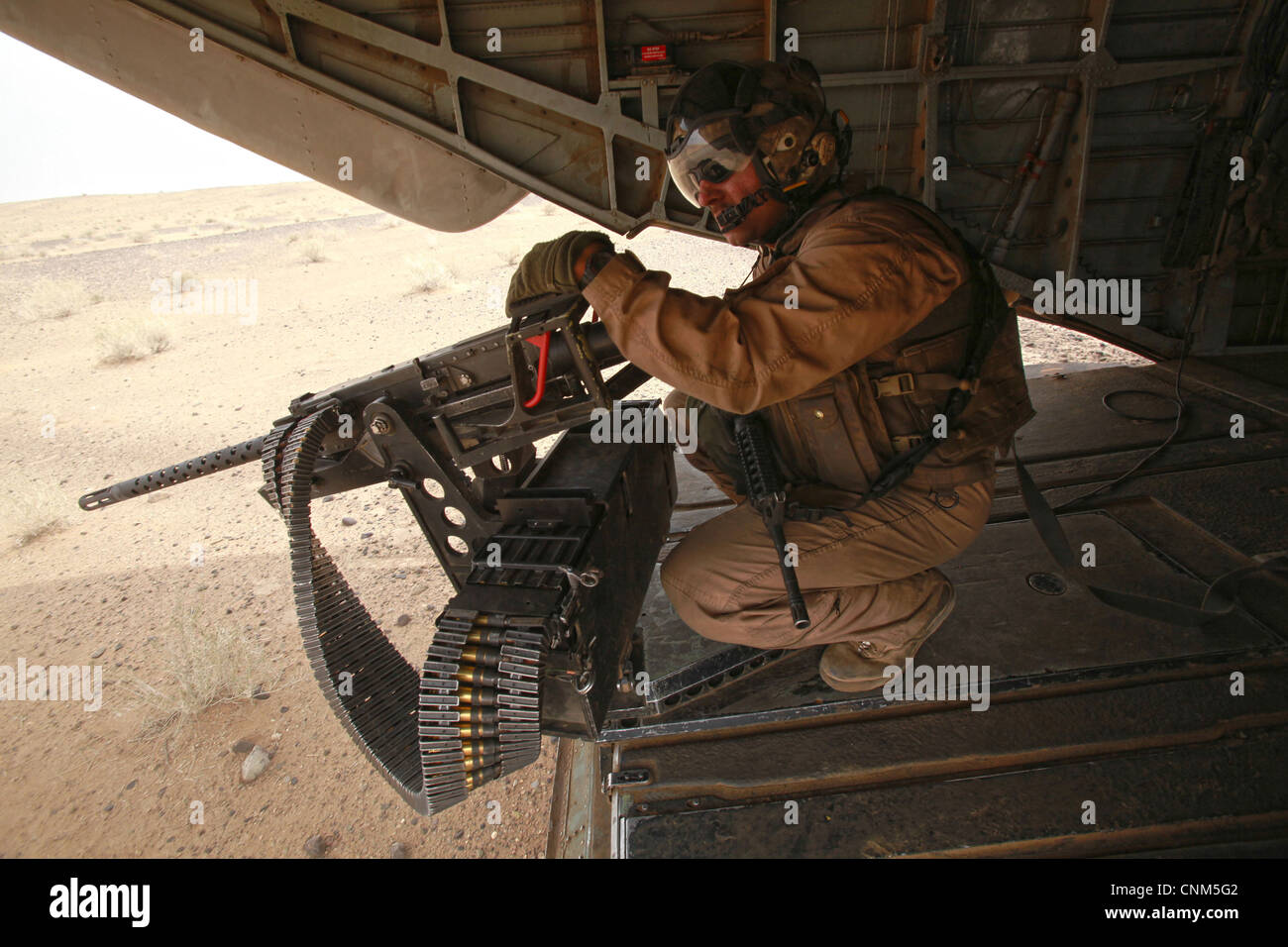 Ein US-Marine sucht nach Aktivität während der Besatzung einer.50 Kaliber Maschinengewehr aus der Backoff-ein Chinook-Hubschrauber während des Betriebs 7. April 2012 in der südlichen Helmand Provinz, Afghanistan. Stockfoto