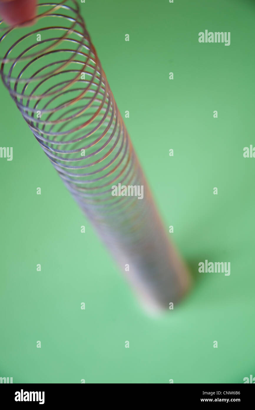 Slinky oder Lazy Frühjahr Spielzeug gemacht der eine spiralförmige Feder, die erstreckt sich und kann auf und ab hüpfen Stockfoto