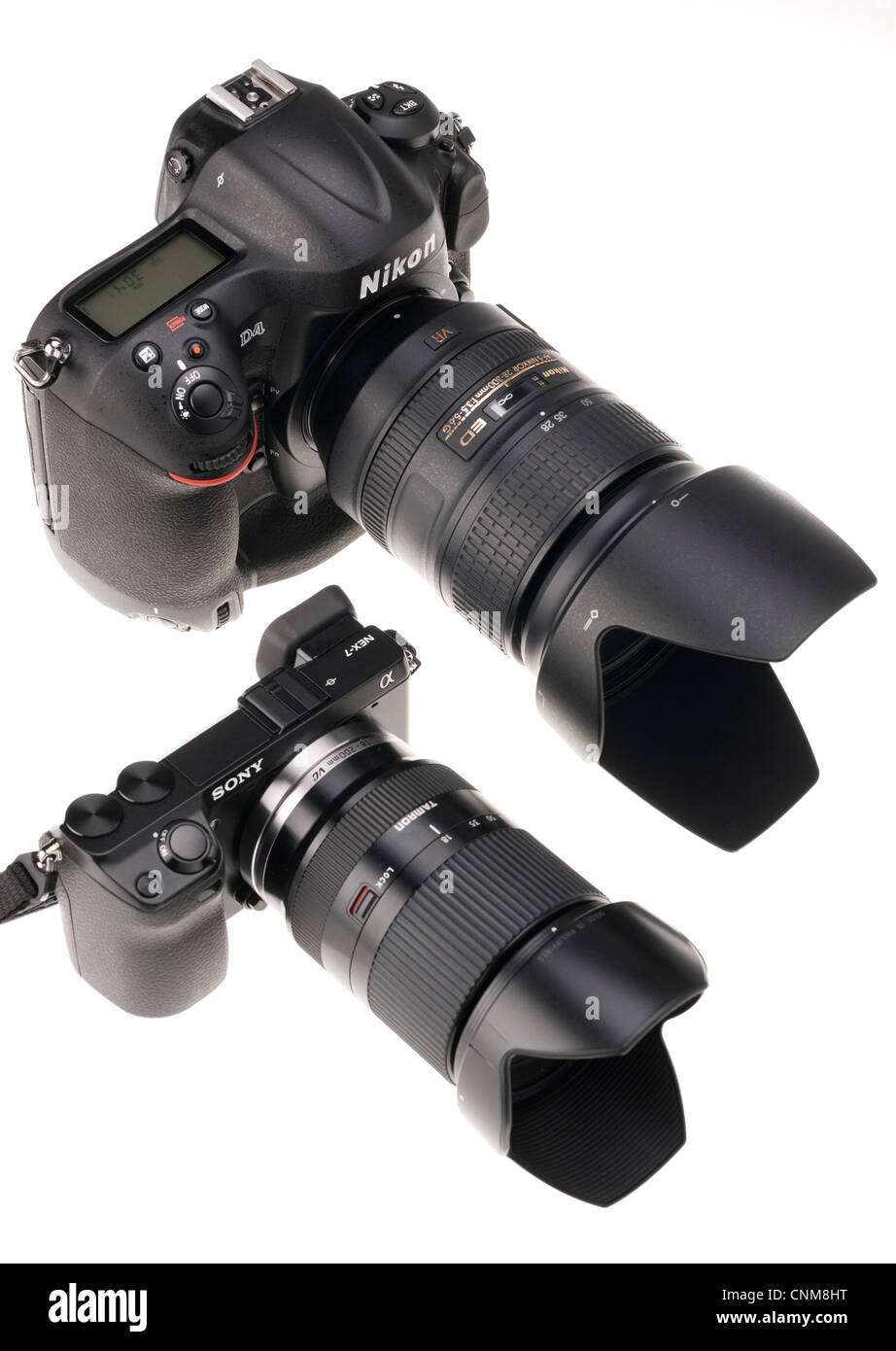Fotoausrüstung - Nikon D4 mit 28-300mm Objektiv gesehen neben Sony NEX-7 mit 18-200mm Objektiv (Größenordnung). Stockfoto