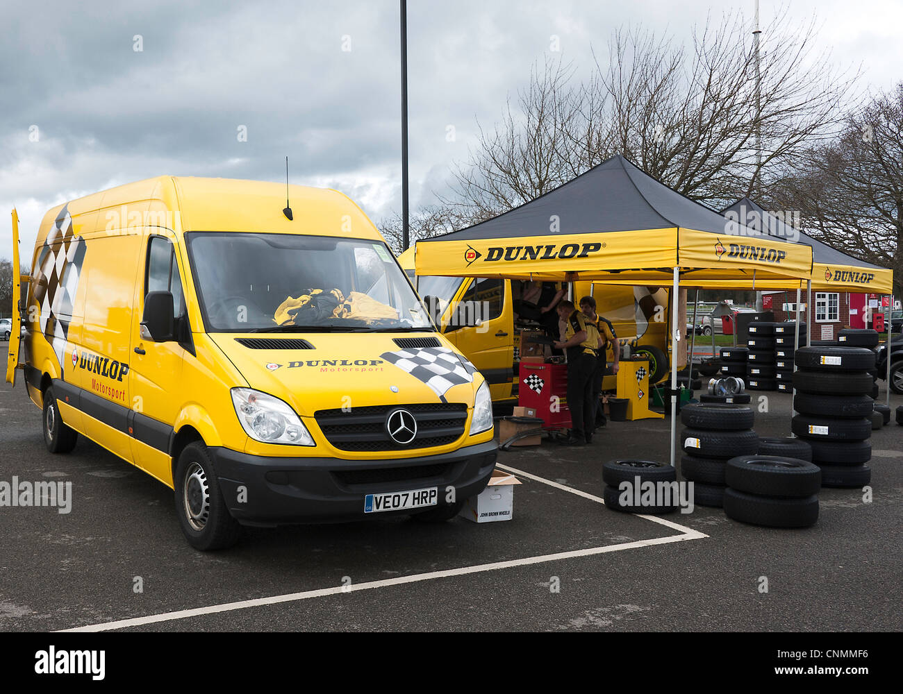 Qualifizierte Dunlop Reifen Mechanik arbeiten auf Rennreifen im Fahrerlager am Oulton Park Autorennen Schaltung Cheshire England UK Stockfoto