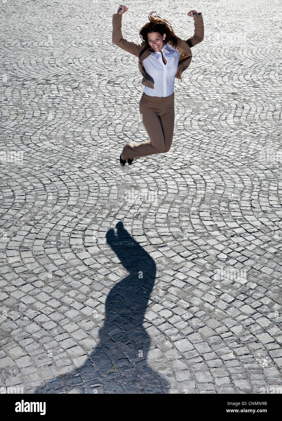 Geschäftsfrau, die springen auf gepflasterten Straße Stockfoto