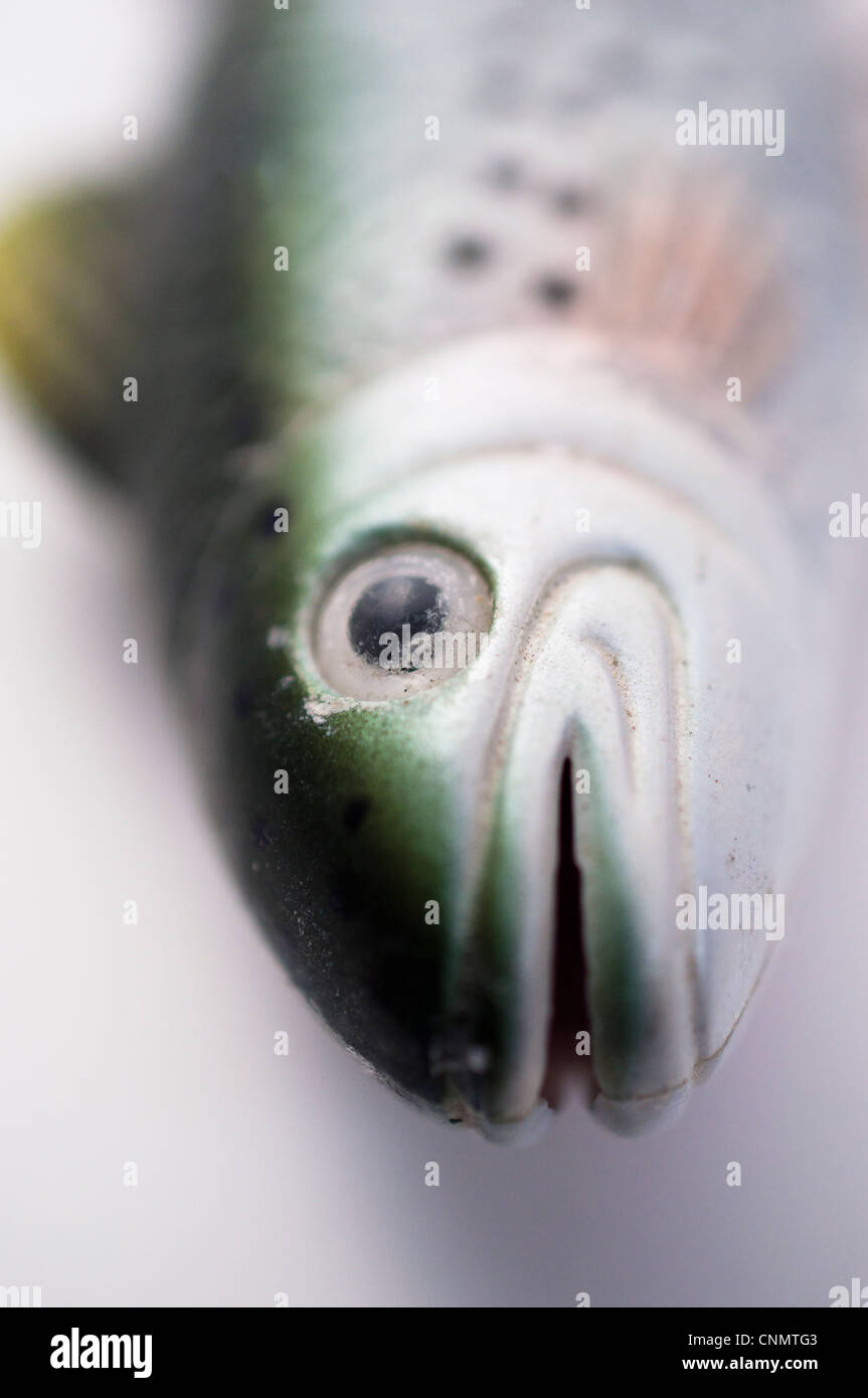 Fisch aus dem Wasser - ein Spielzeug-Uhrwerk Fisch auf einem weißen Hintergrund - flachen DOF Stockfoto