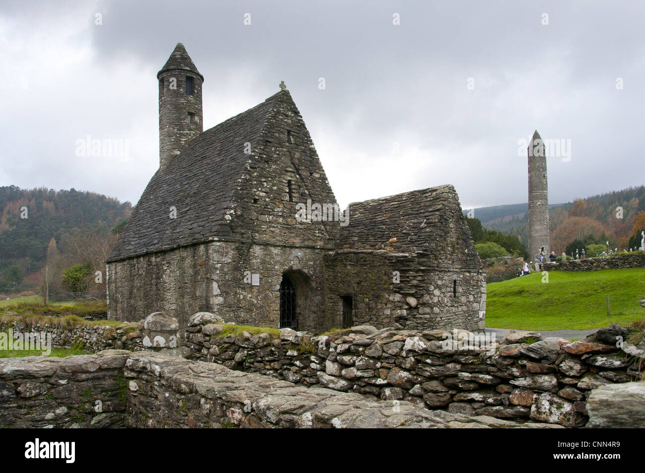 Frühen mittelalterlichen Klostergebäude St Kevins Kirche runden Turm Glendalough klösterlichen Website Wicklow Weg Walking Route Glendalough Stockfoto